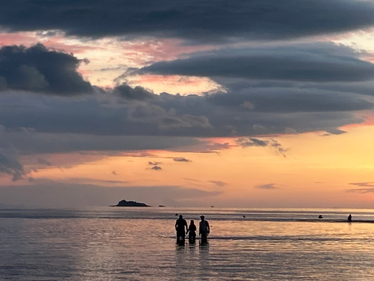 Dramatic sunset over Koh Phangan waters with storm clouds