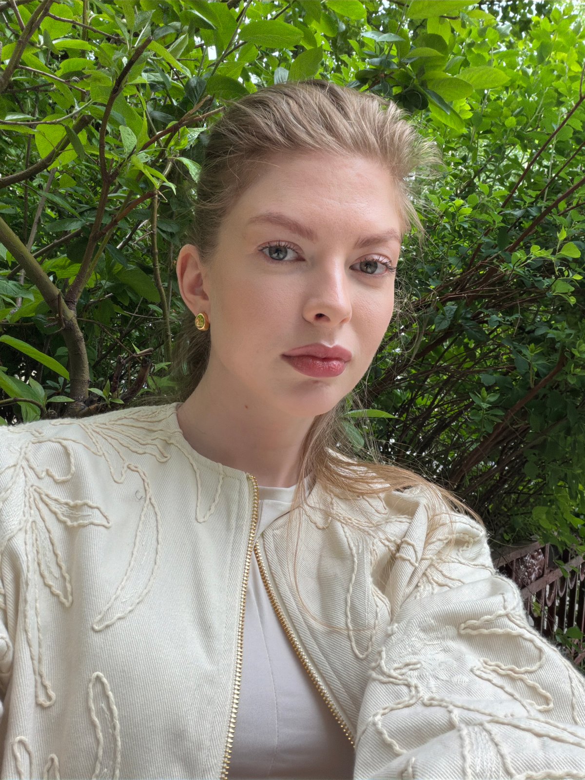 Woman poses for selfie among greenery in Moscow