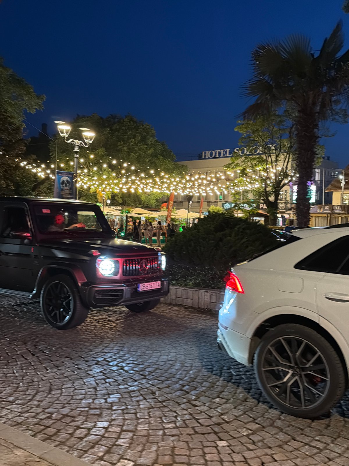 Summer night in Sozopol: street art, parrot show, and parked SUVs