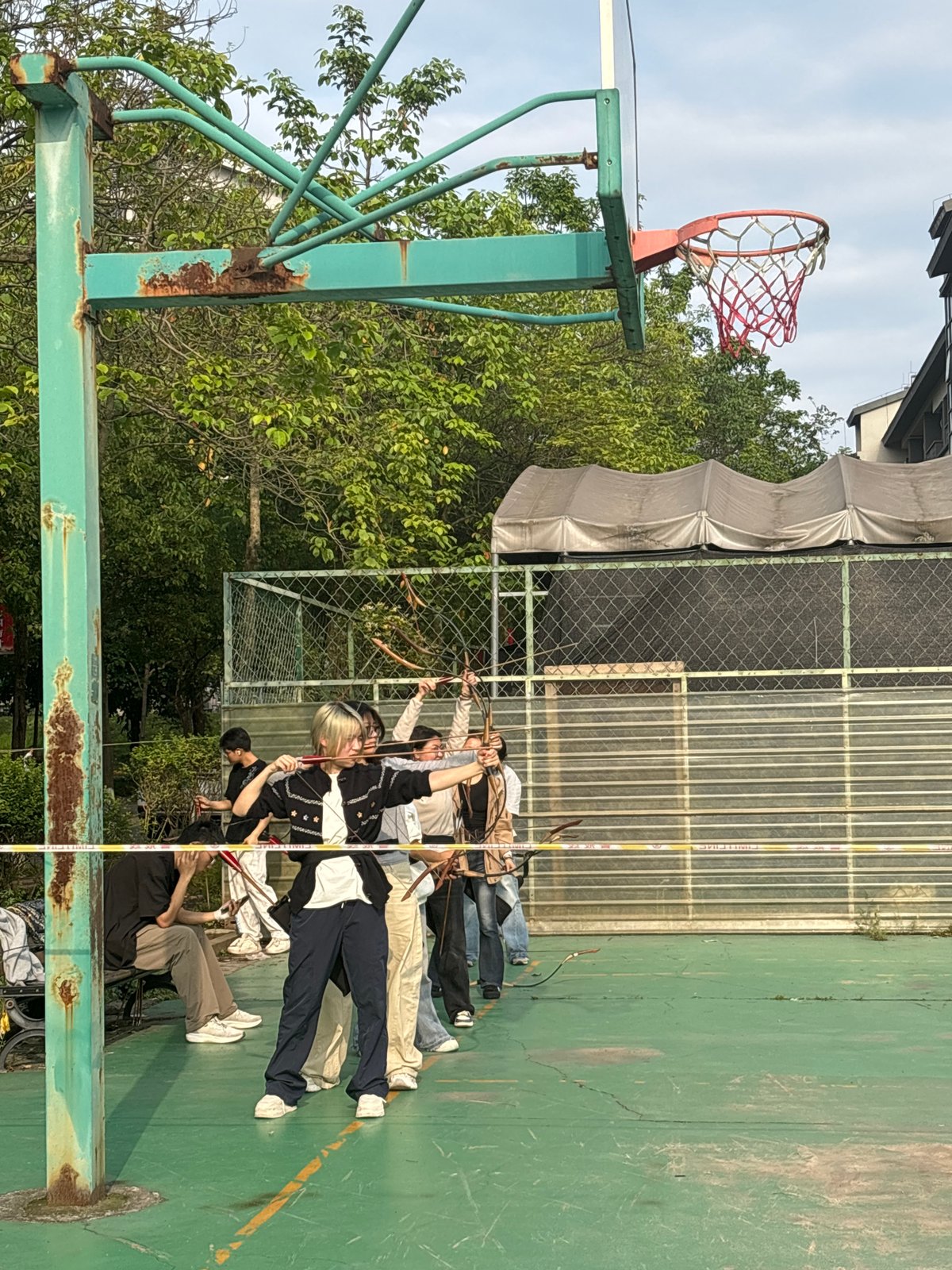 Archery group practices on basketball court in Jiangjin park