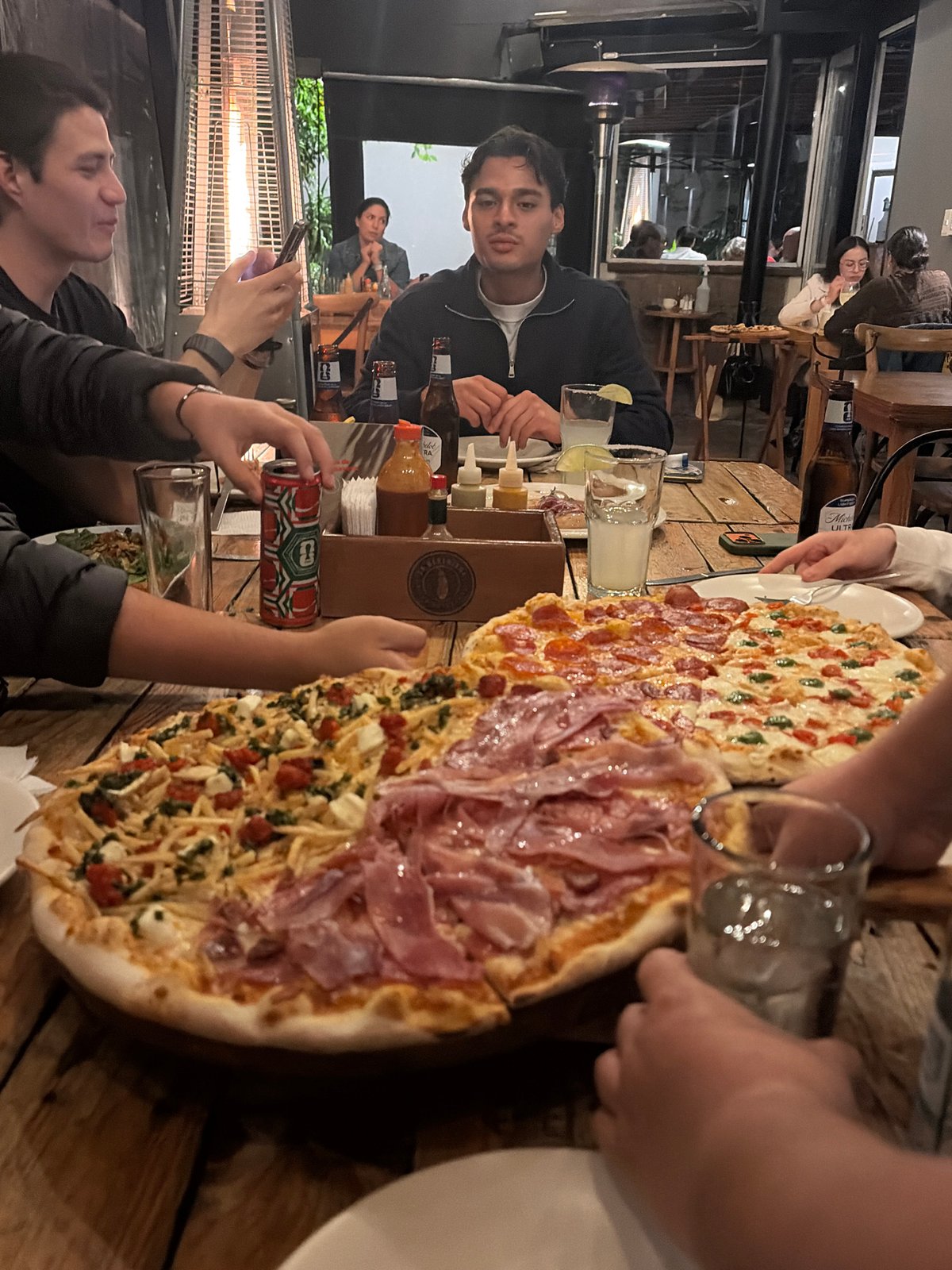 Late-night pizza gathering captured at outdoor restaurant patio