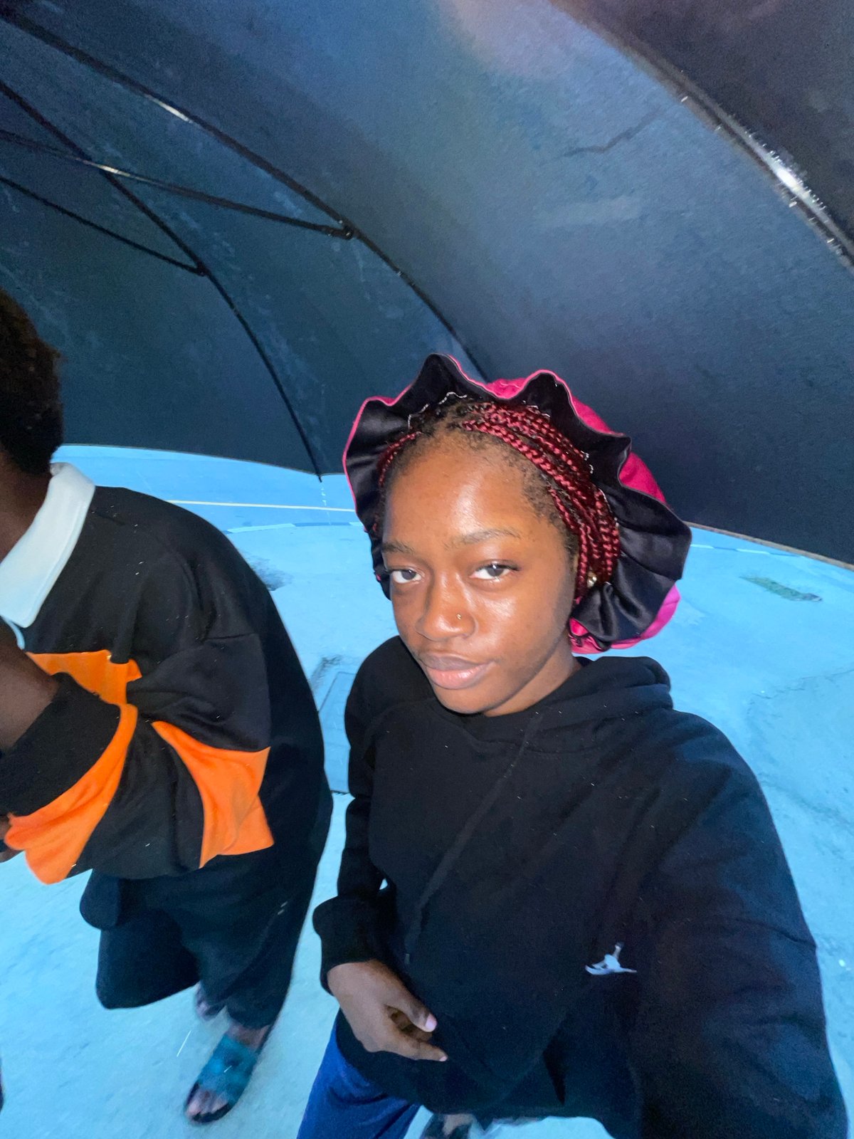 Sheltering under an umbrella on a rainy Igboefon morning