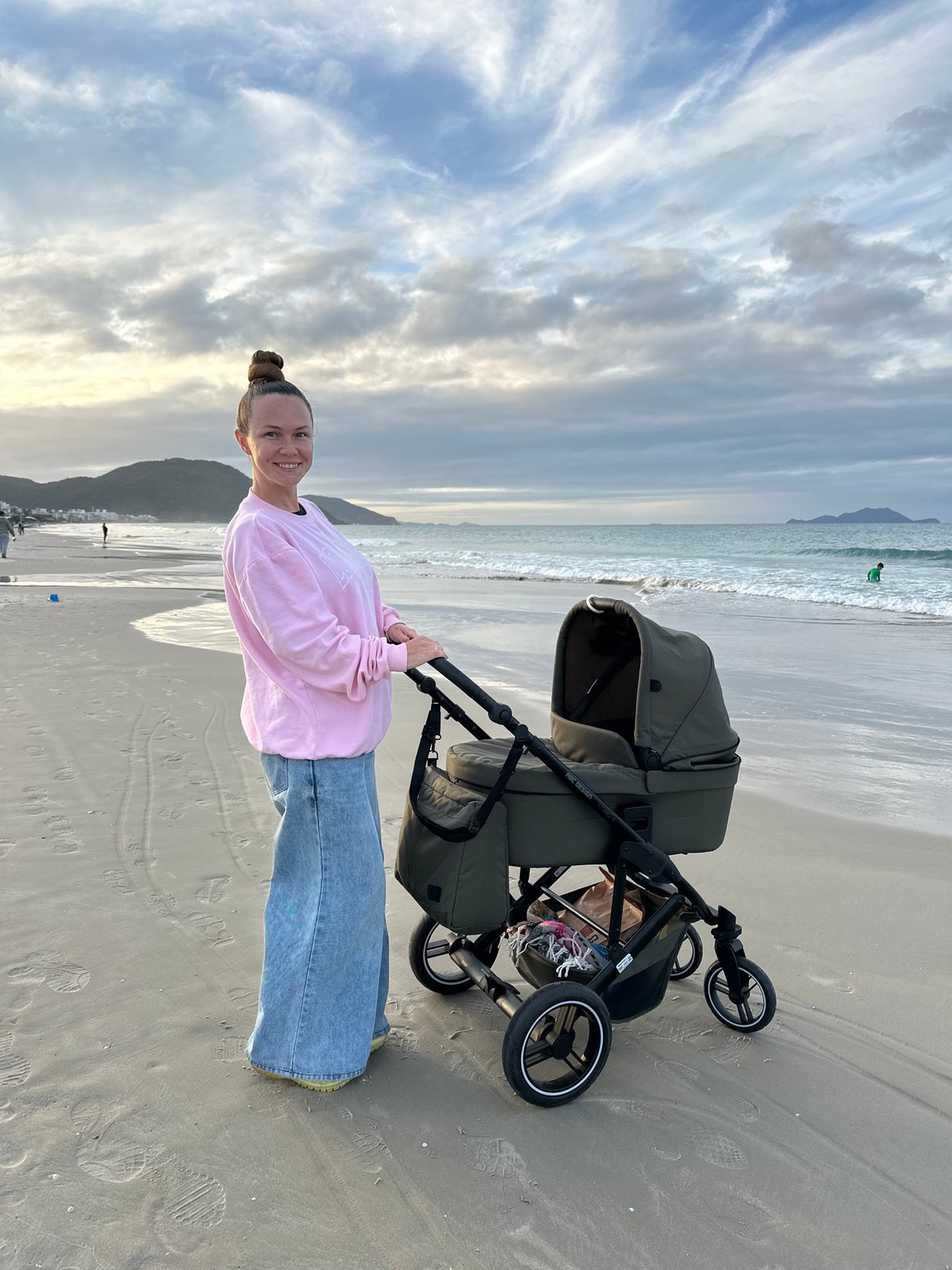 Woman with baby stroller enjoys beach day in Florianópolis