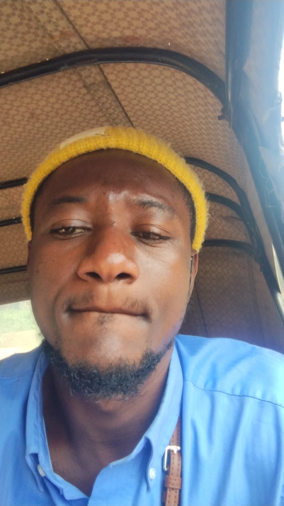 Close-up selfie in Jos, Nigeria, yellow beanie and blue shirt