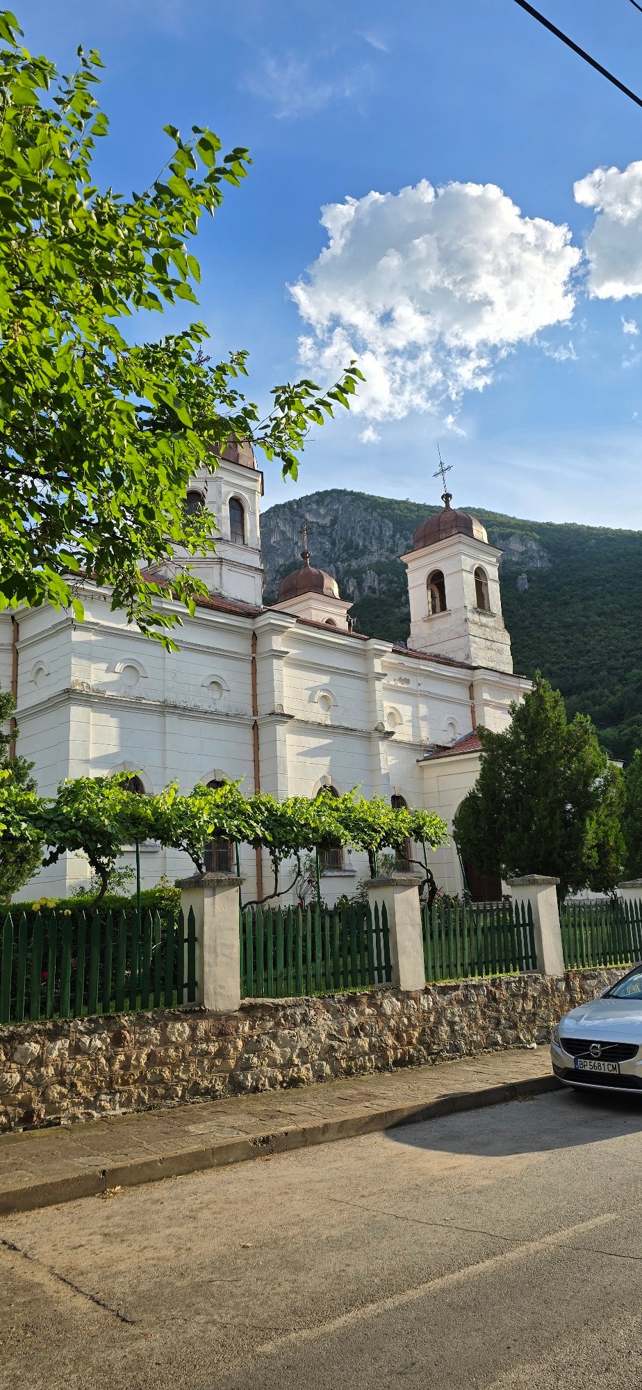 White domed church in green hills on a sunny day