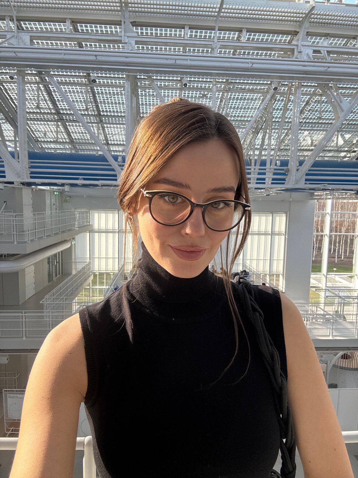 Woman takes selfie near modern architecture in Moscow