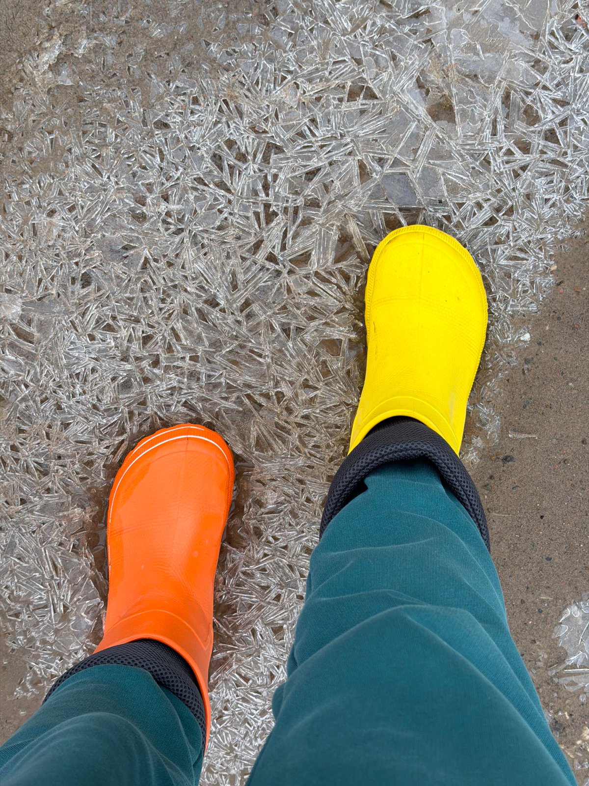 Woman in mismatched boots walks through puddles in Russia