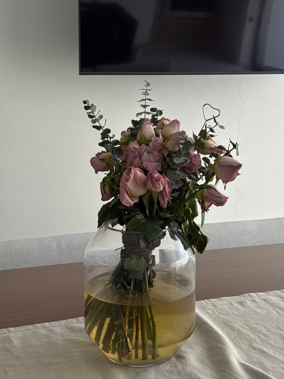 Dried pink roses displayed in glass vase in Puebla