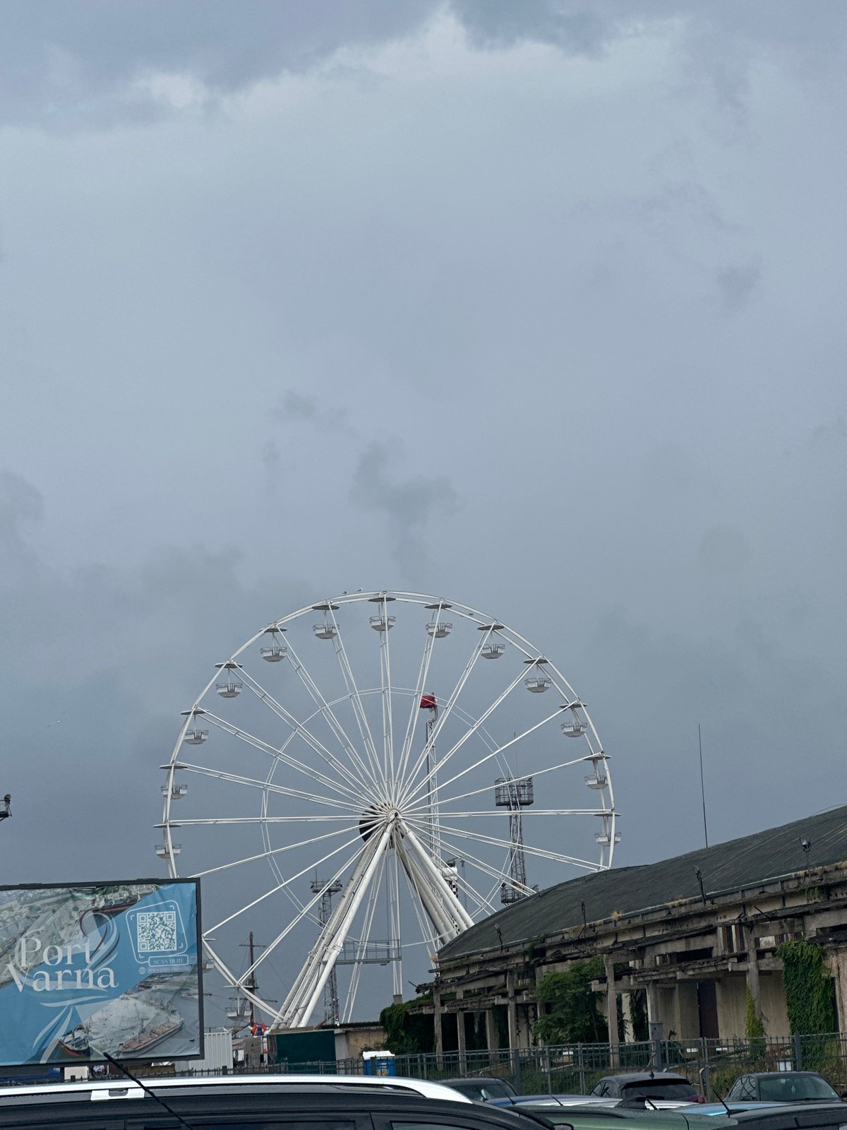 Ferris wheel, harbor cranes, and city views on a cloudy morning
