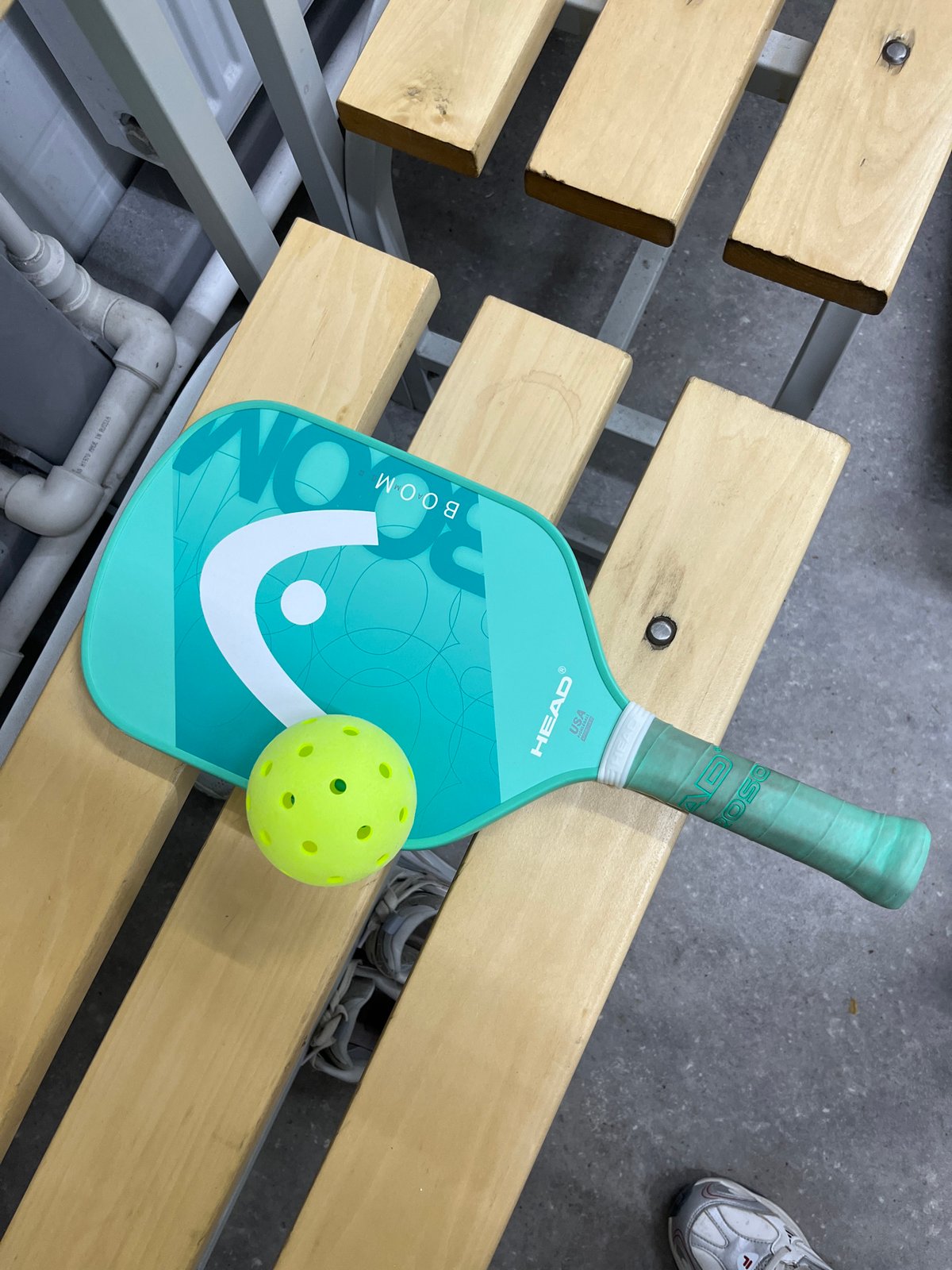 Pickleball equipment spotted on wooden bench