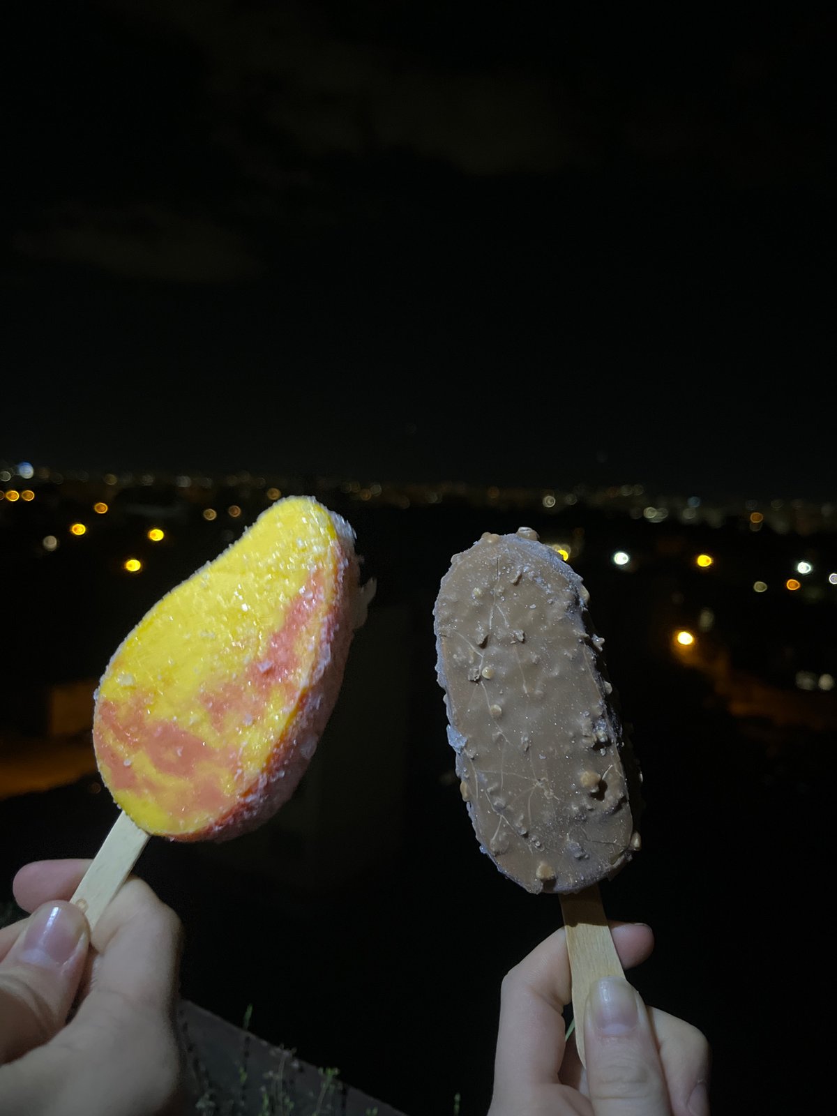 Evening ice cream sharing documented during nighttime walk in Sofia