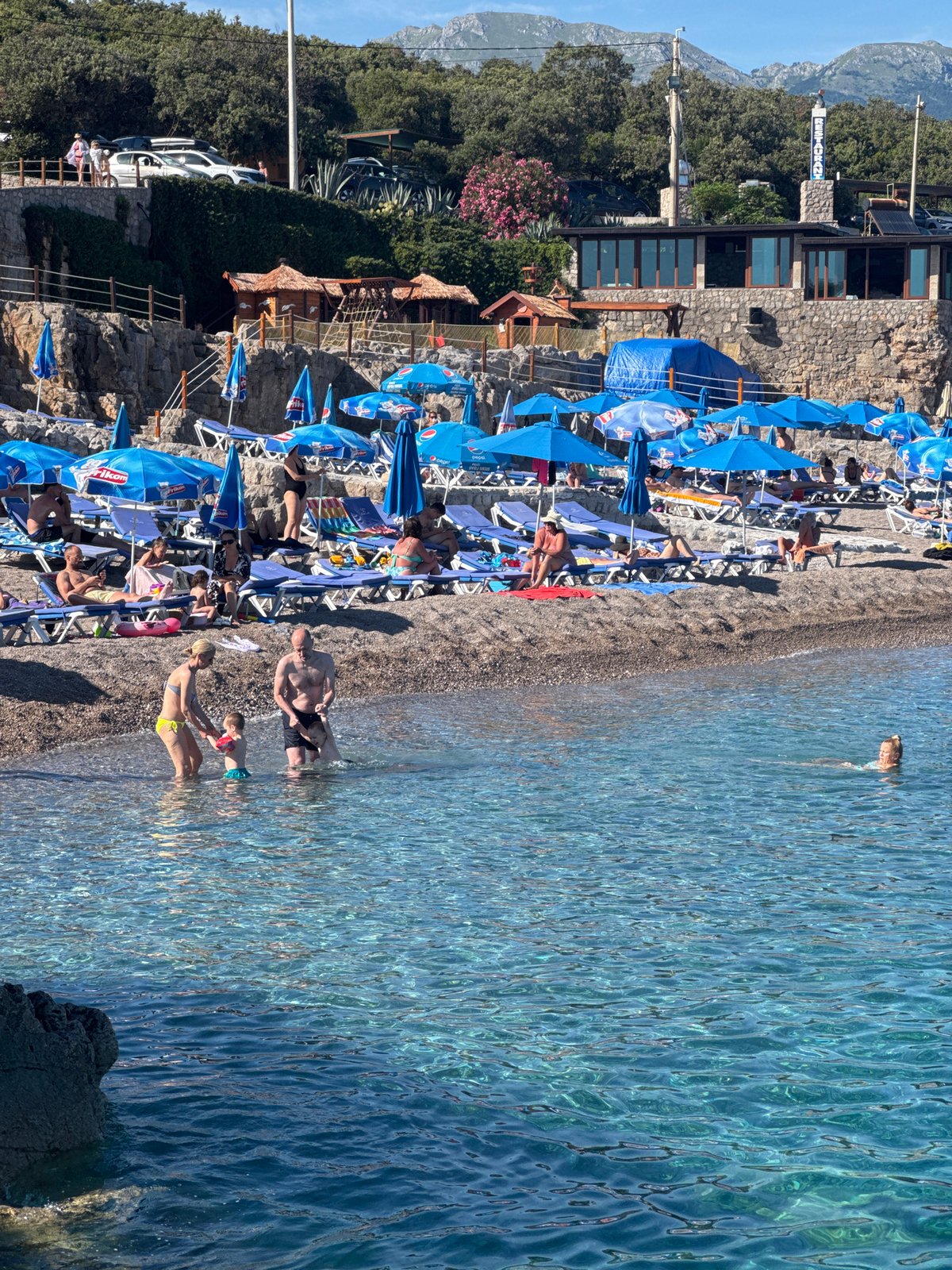 Summer beach day at Prijevor with water park and boats
