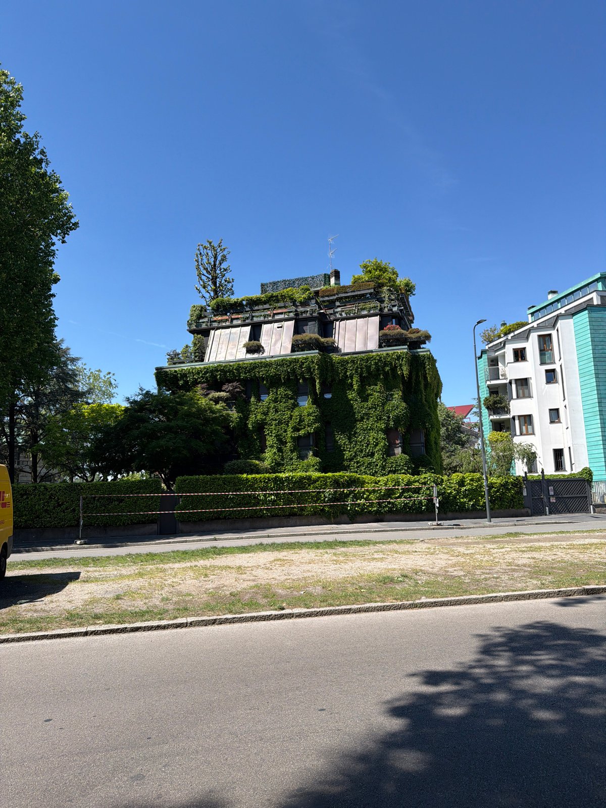 Green-integrated buildings observed in sunlit Milan street scene