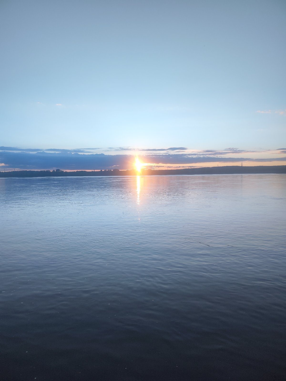 Sunset documented over water body near Noviy, Russia