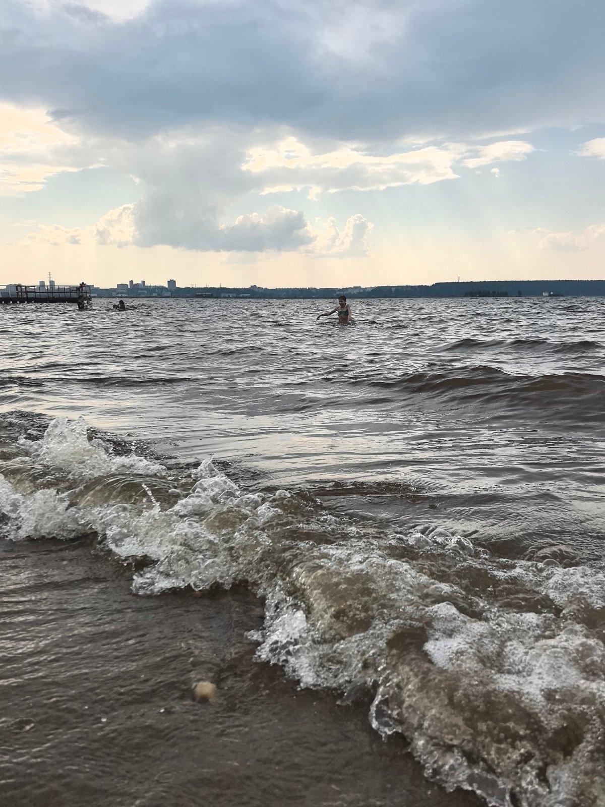 Kama River beach in Perm draws a crowd on a cloudy summer day