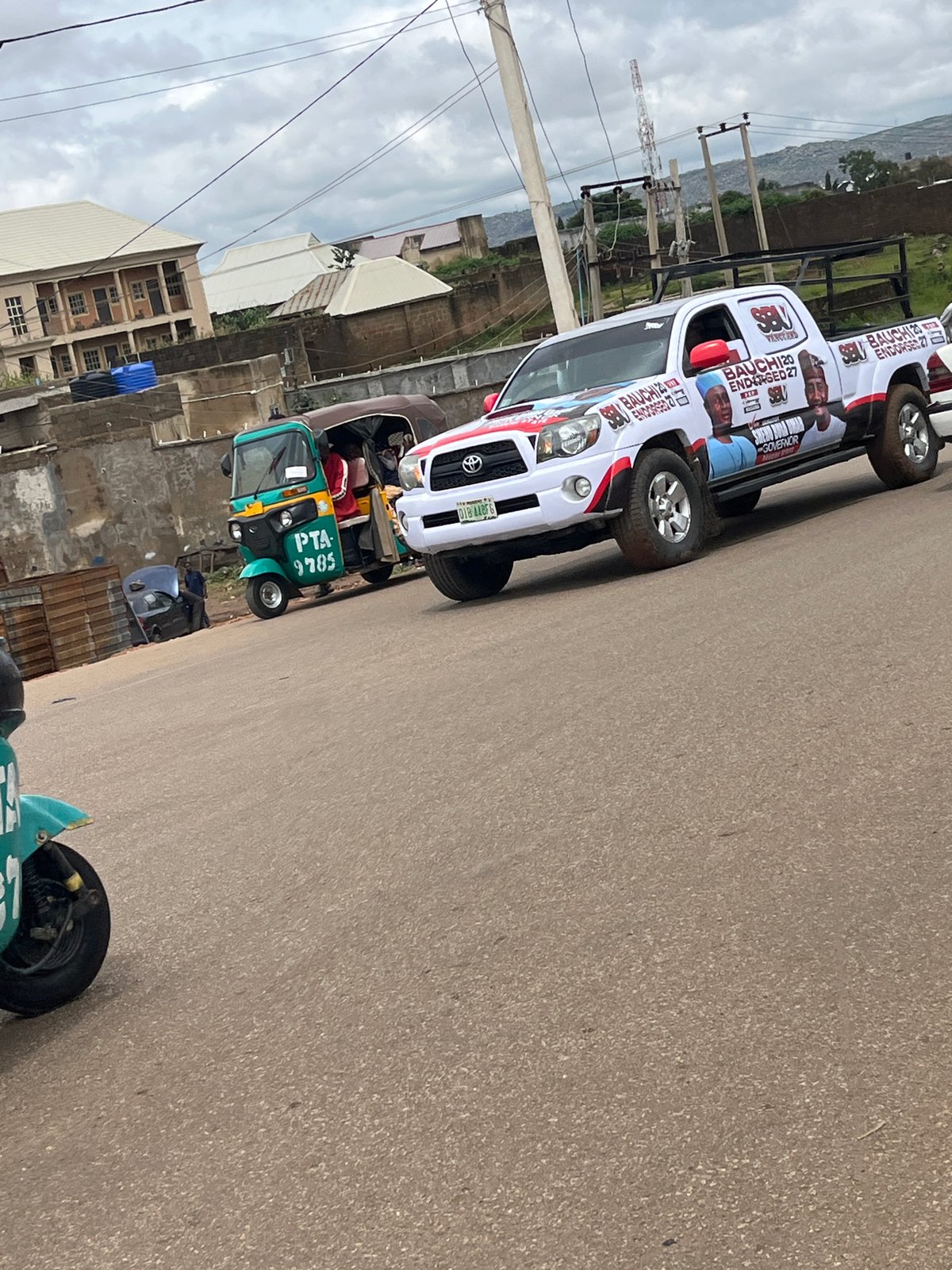 Jos street traffic: campaign trucks, keke, and street commerce