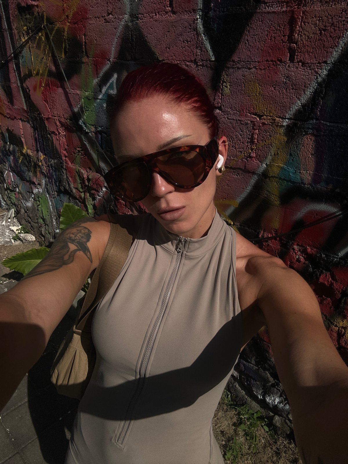Tattooed person photographed near graffiti wall in North Kuta
