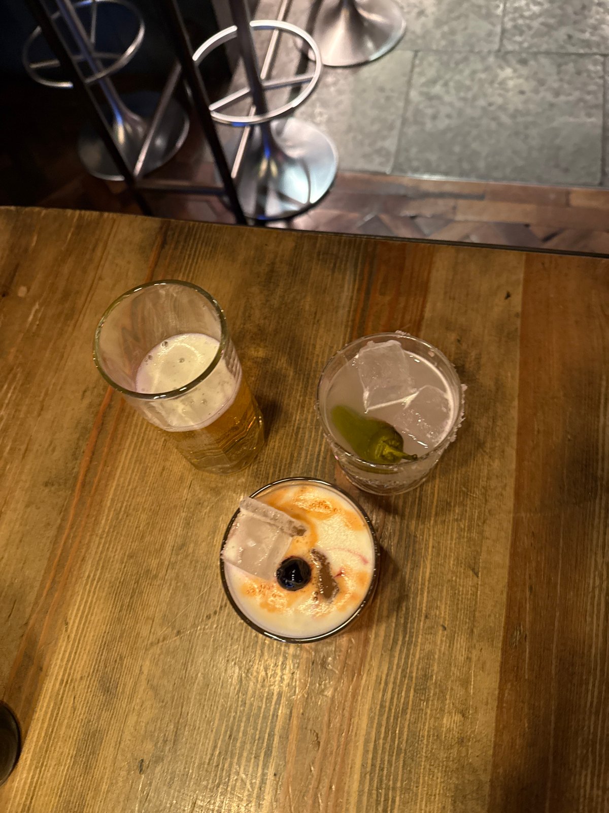 Three drinks served at London bar during evening hours