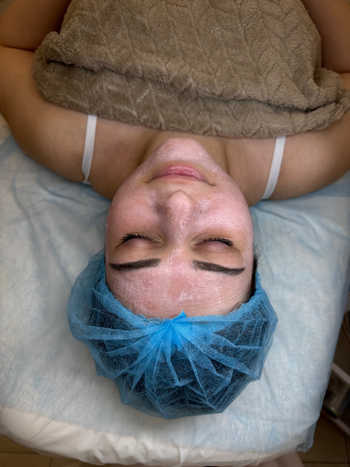 Person receives facial treatment at beauty salon