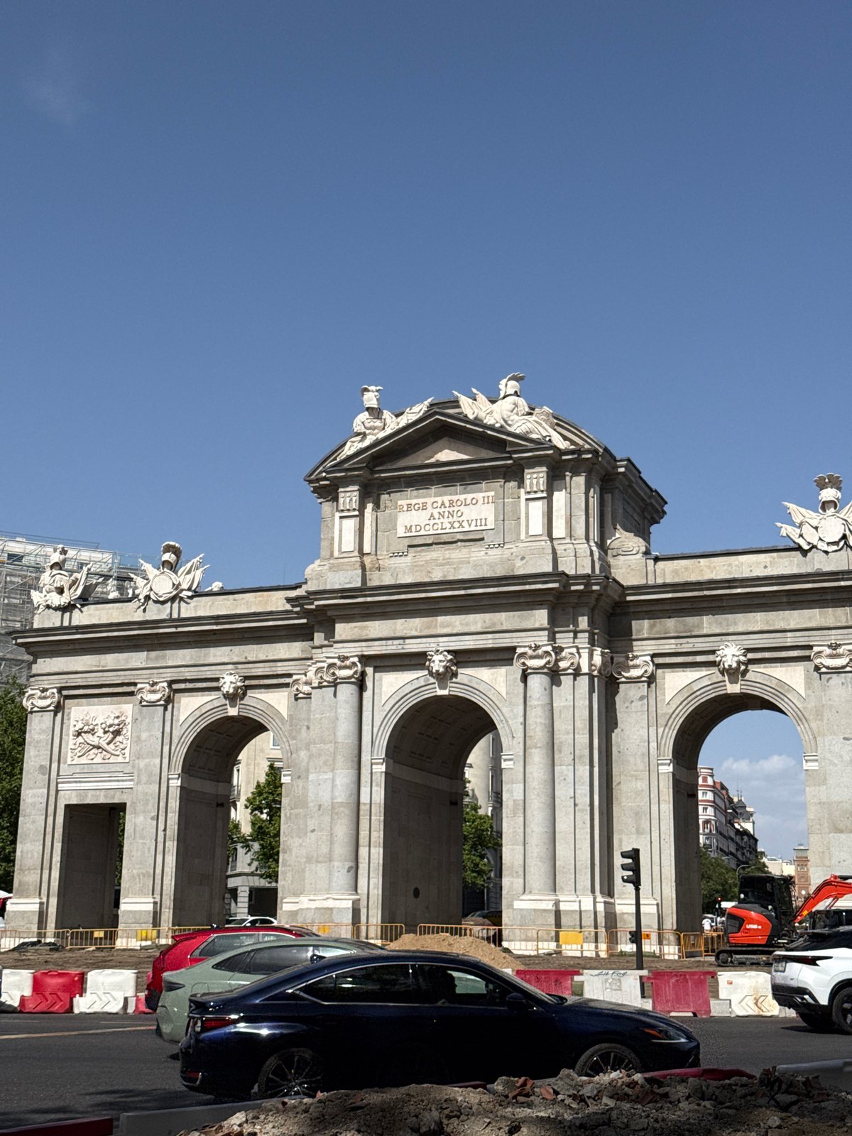 Puerta de Alcalá and a domed church on a clear Madrid afternoon