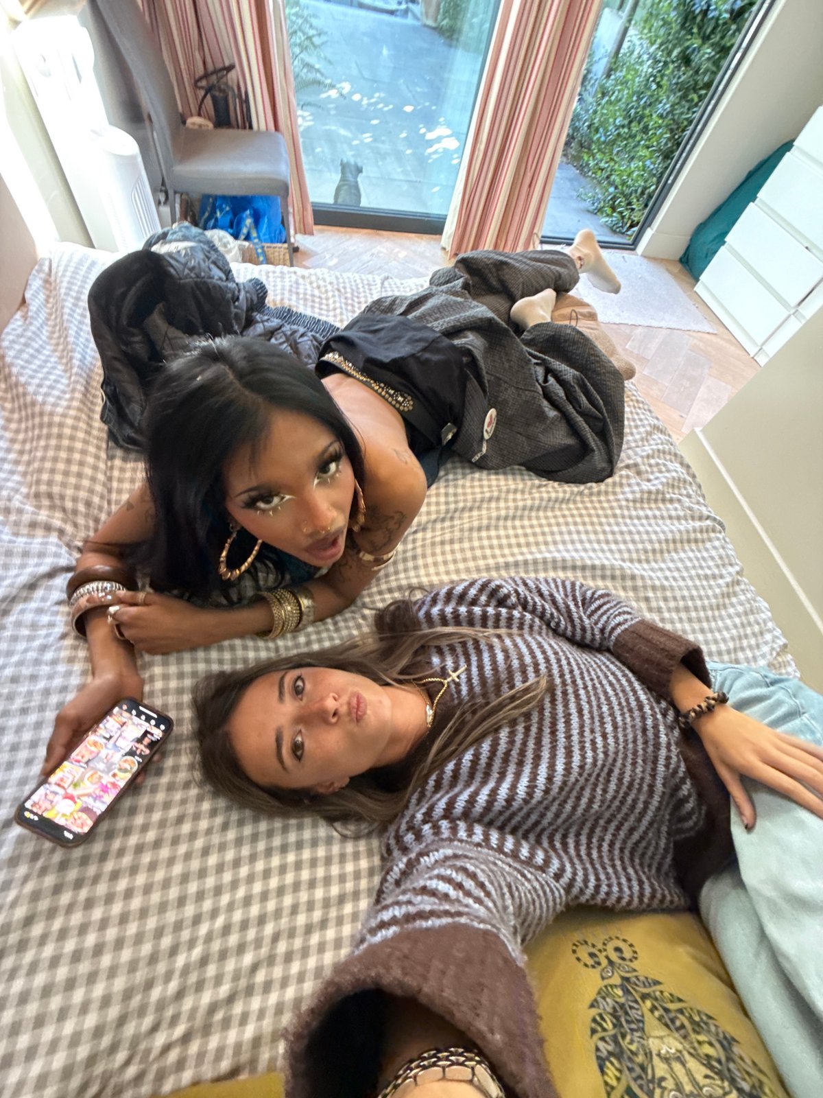 Two women photographed resting on bed in London