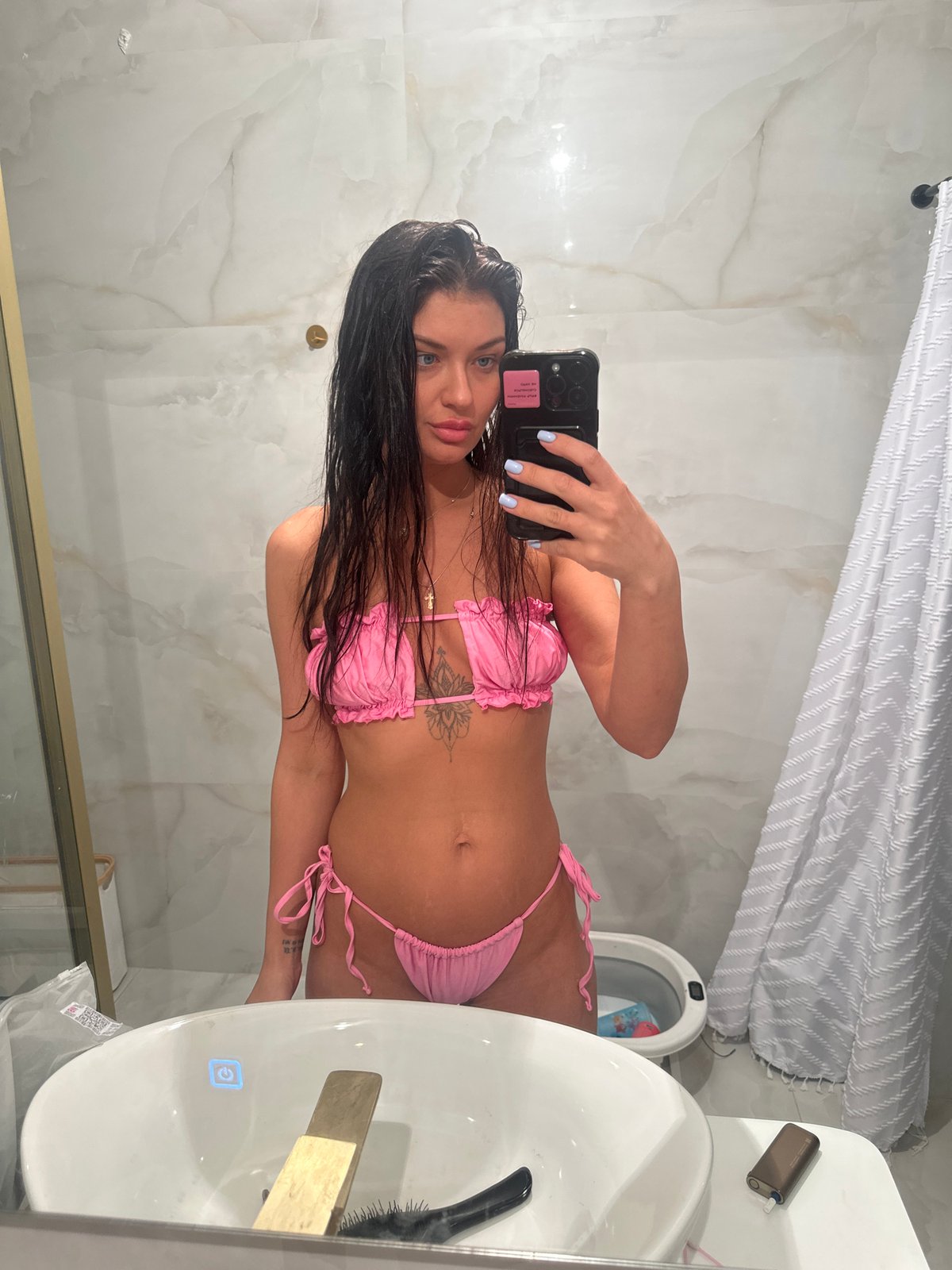 Woman takes bathroom selfie in pink bikini in Moscow