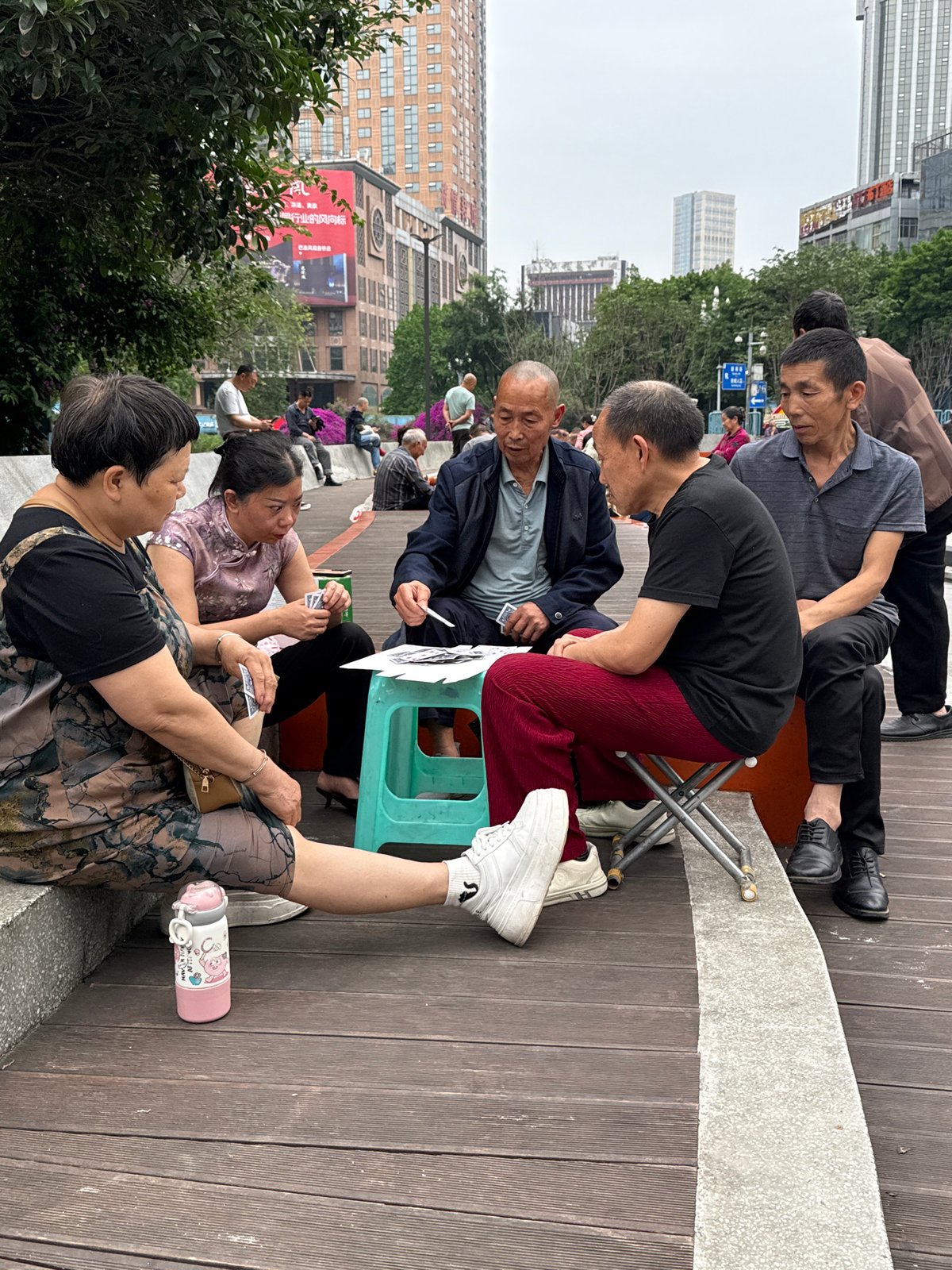 Elderly residents play cards on boardwalk in Nan'an District