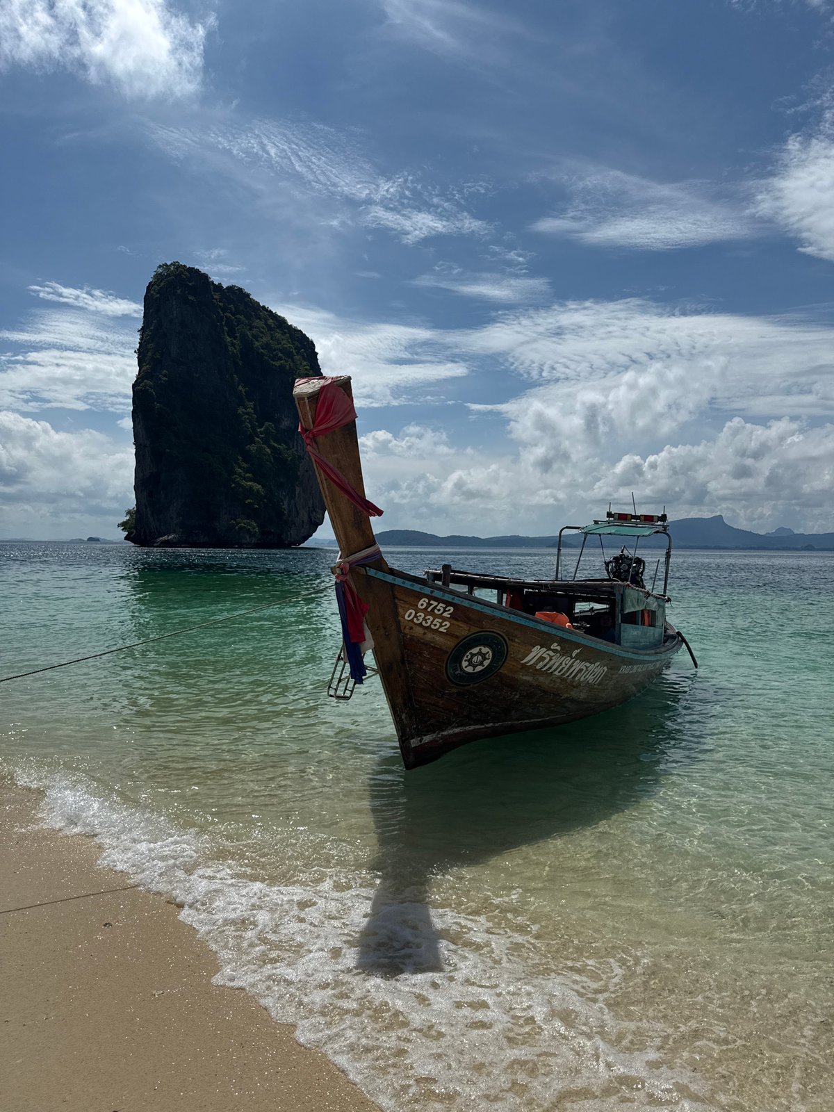 Longtail boat at Ban Ao Nang beach with limestone cliffs