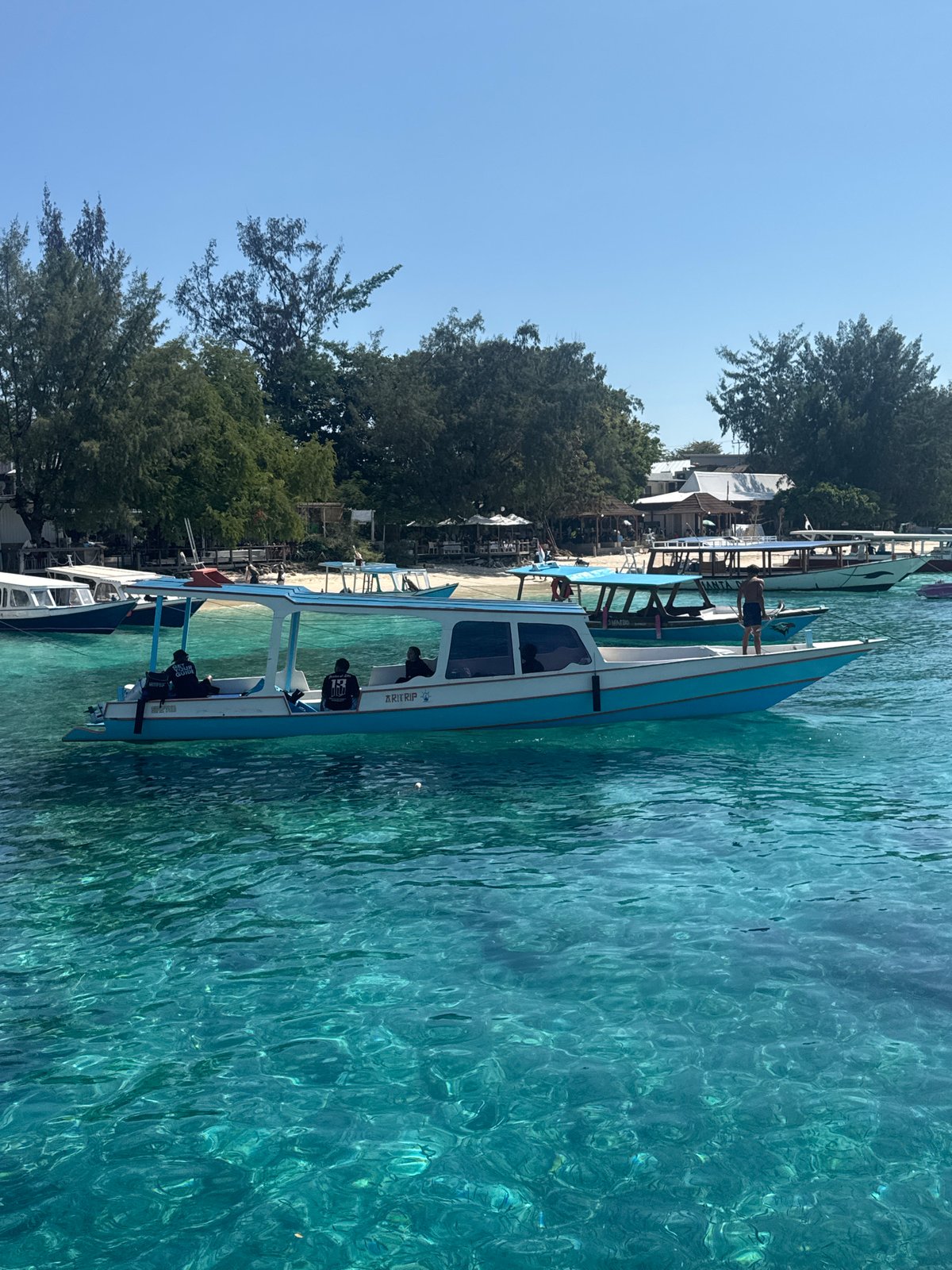 Passenger boat docked at a small Indonesian coastal pier