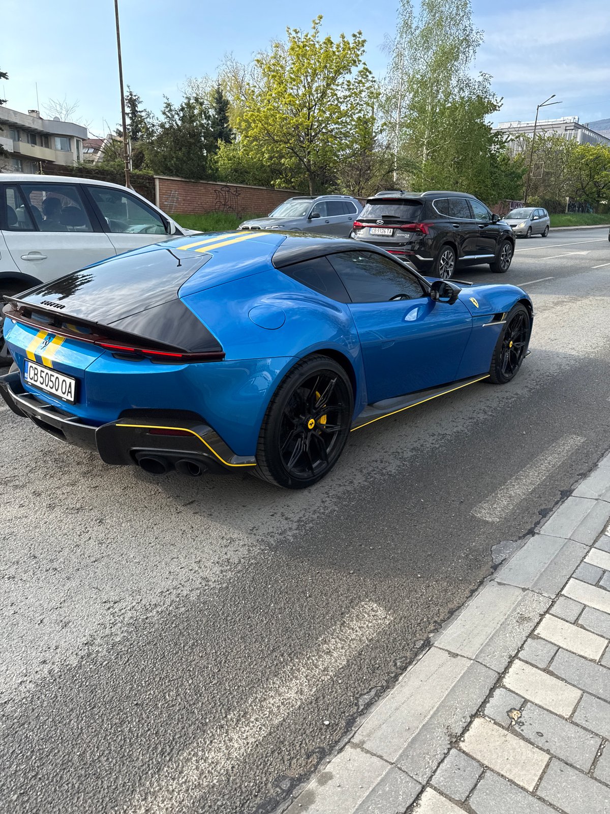 Blue Ferrari spotted on Sofia street amid mountain backdrop