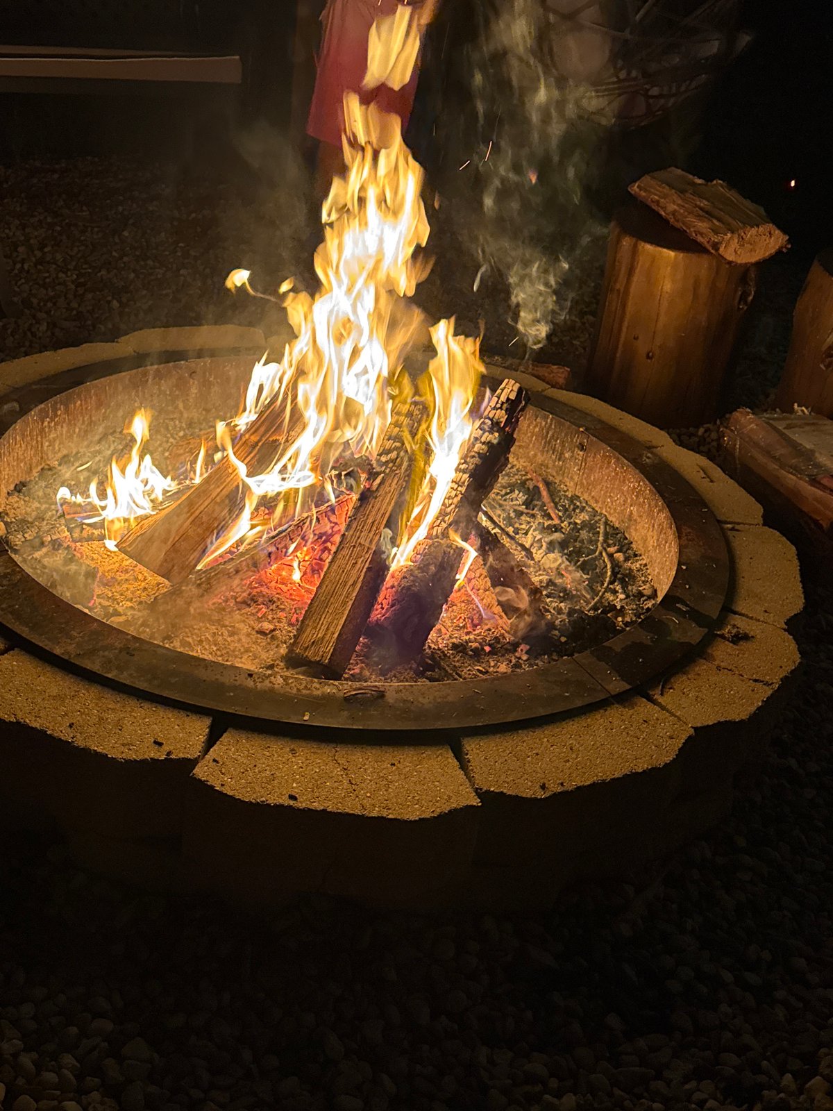 Late night outdoor gathering features fire pit, music, games