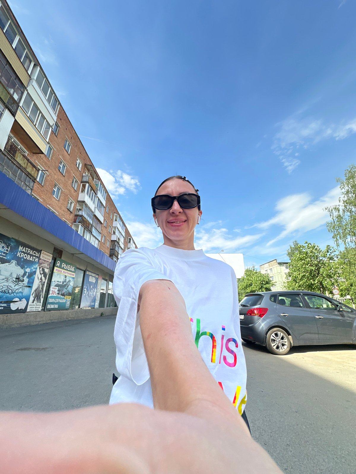 Woman takes morning selfies in rainbow shirt, Votkinsk street