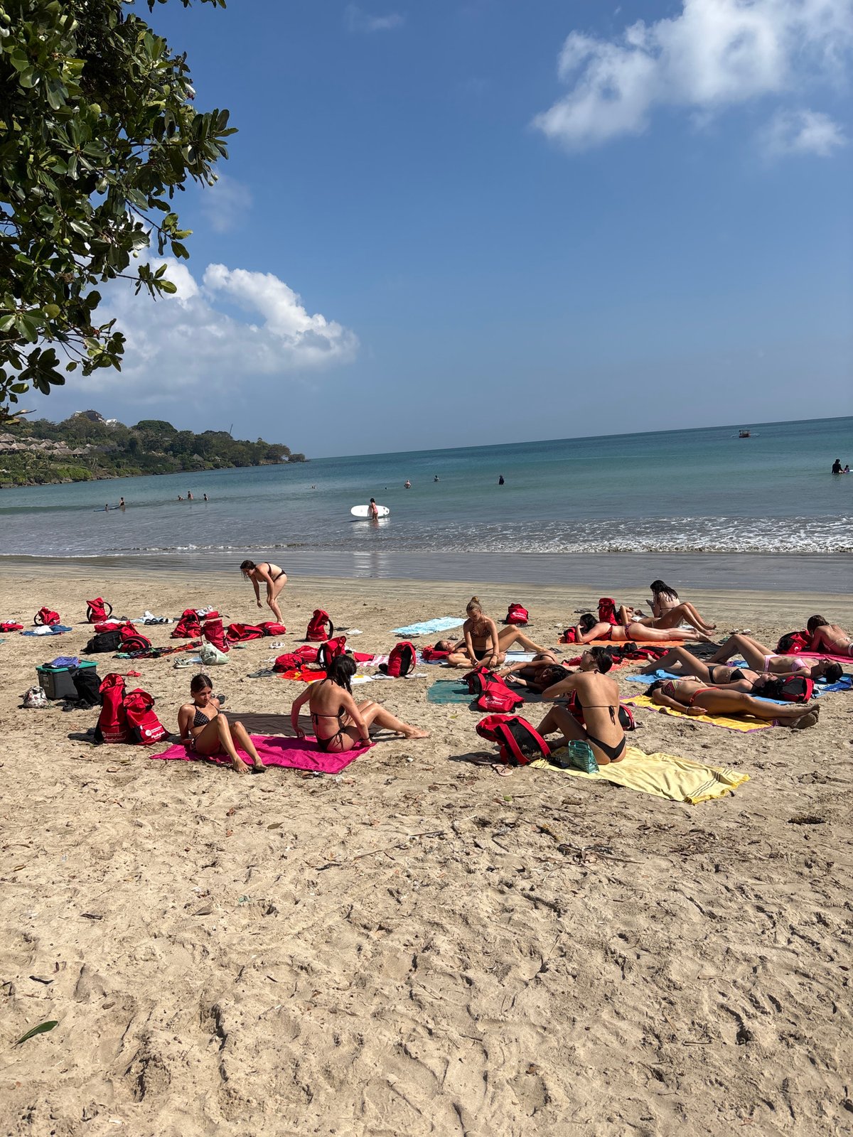 Busy beach day in Kuta Selatan — sunbathers, horses, and fishing boats