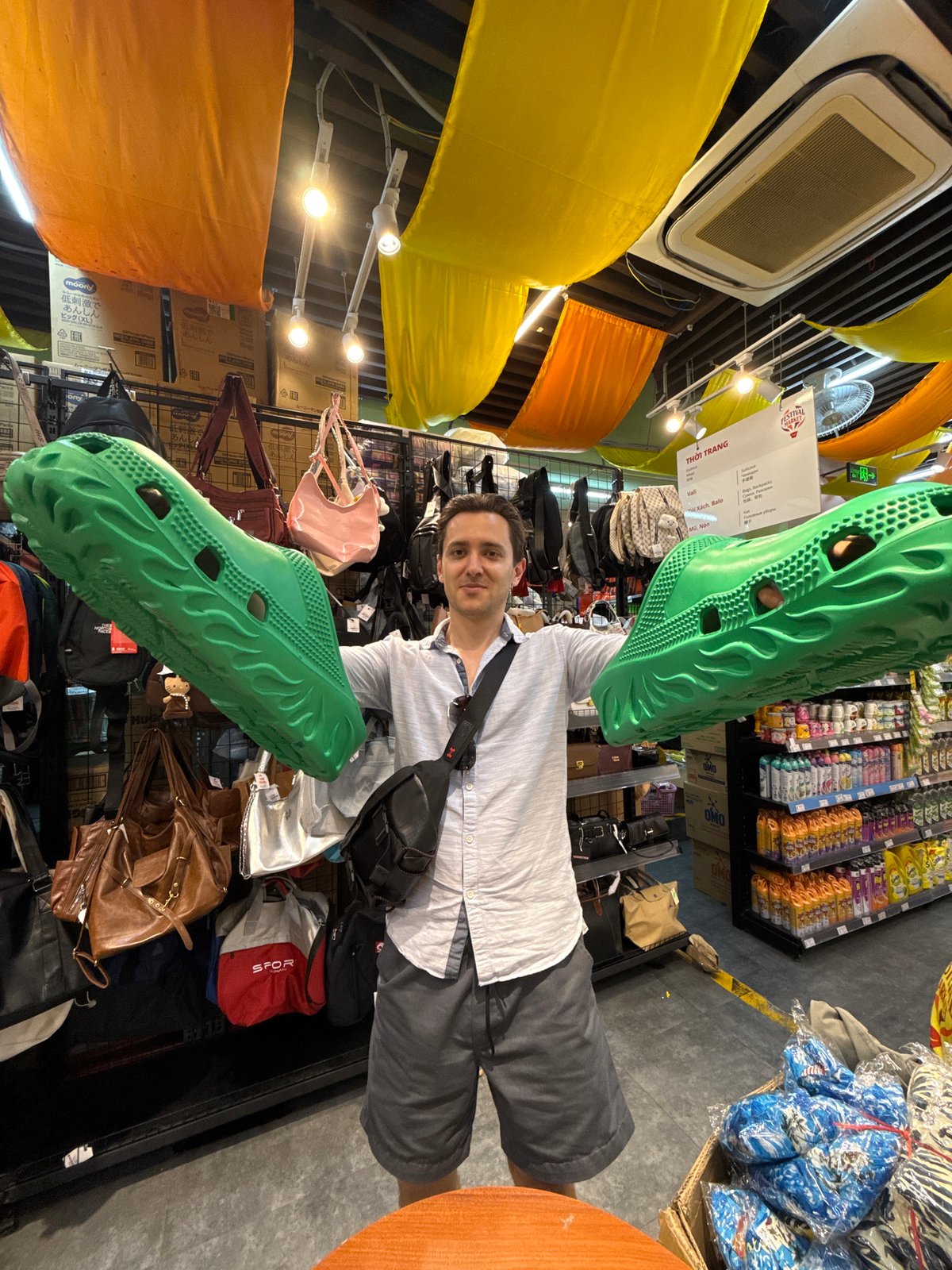 Man examines novelty sandals at Nha Trang retail store