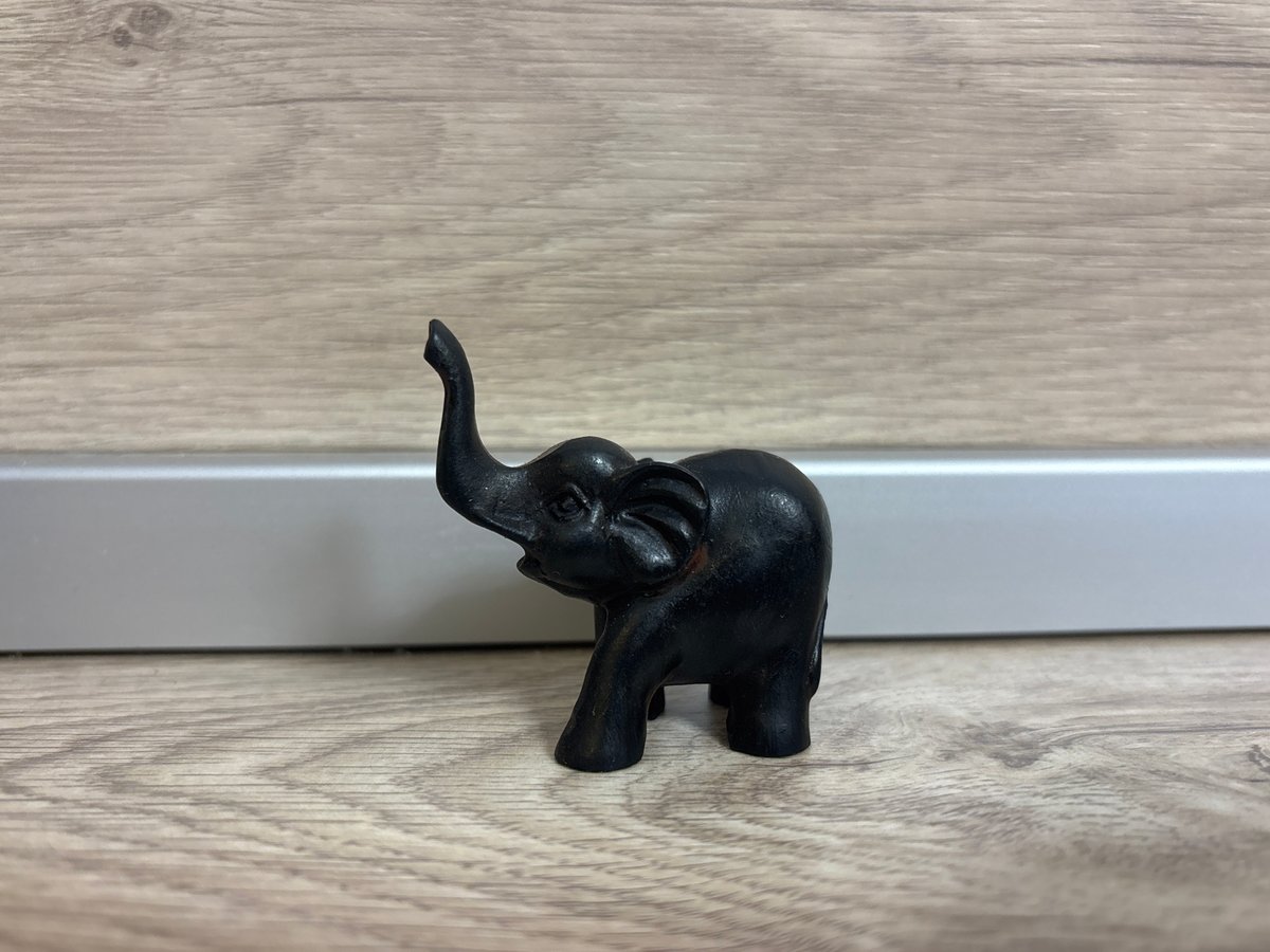 Black elephant figurine spotted on wooden surface