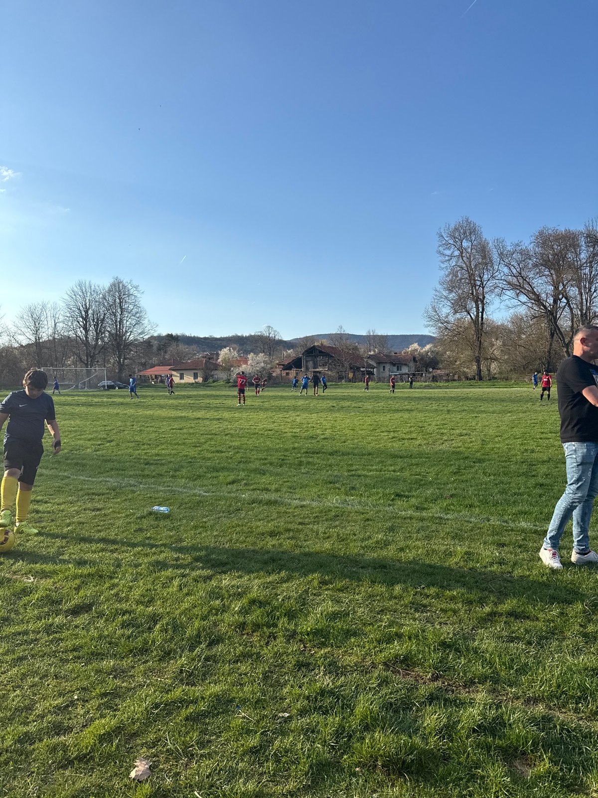 Soccer match unfolds in Dushevo, Bulgaria under sunny skies
