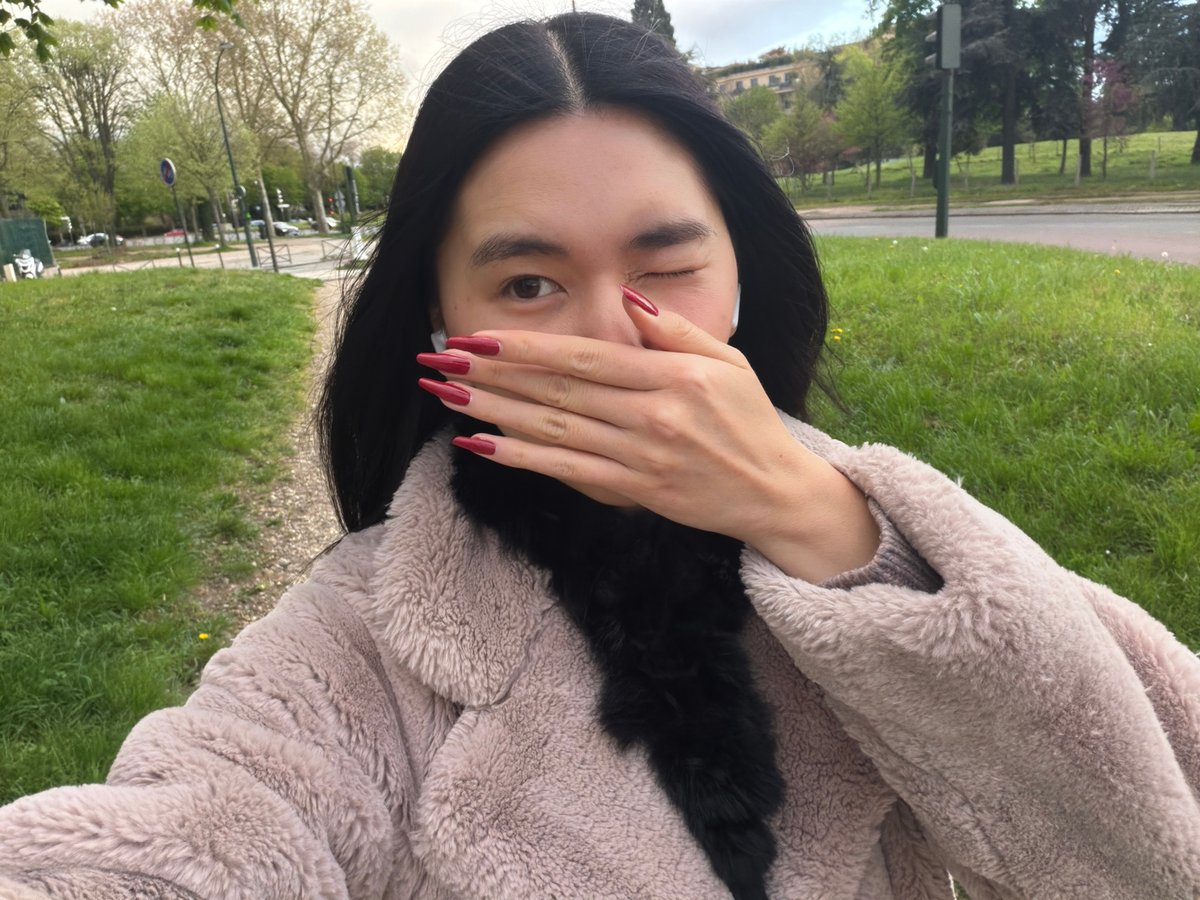 Woman takes playful selfies in Paris park