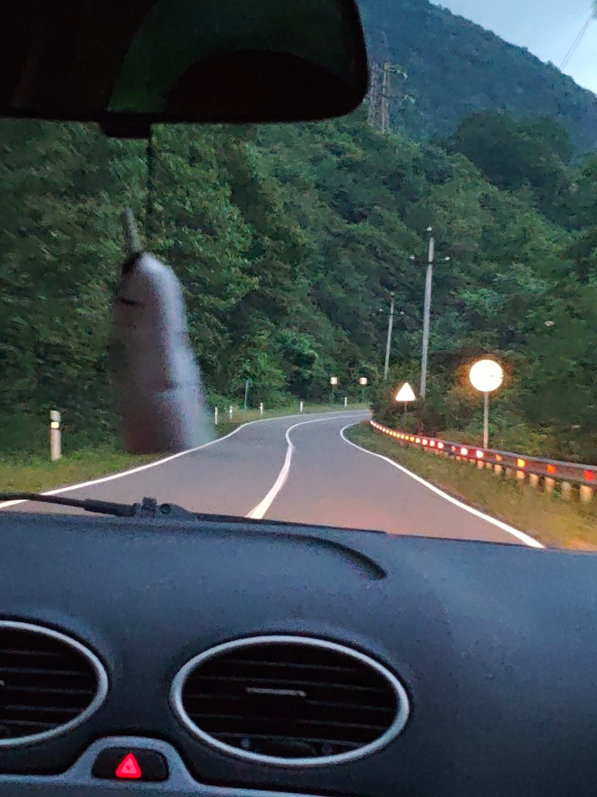 Dashboard view of a winding forest drive, Retro FM playing.