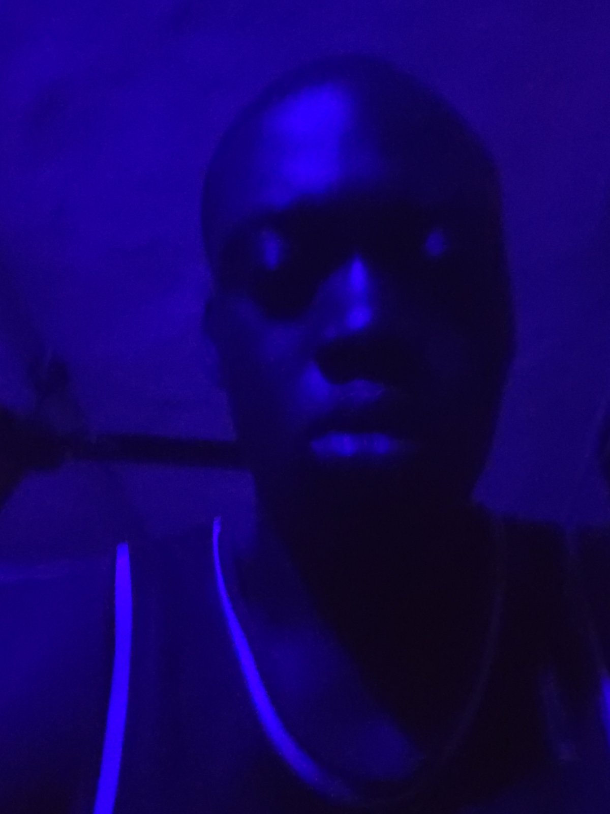 Dark figure illuminated by blue light observed in unknown location