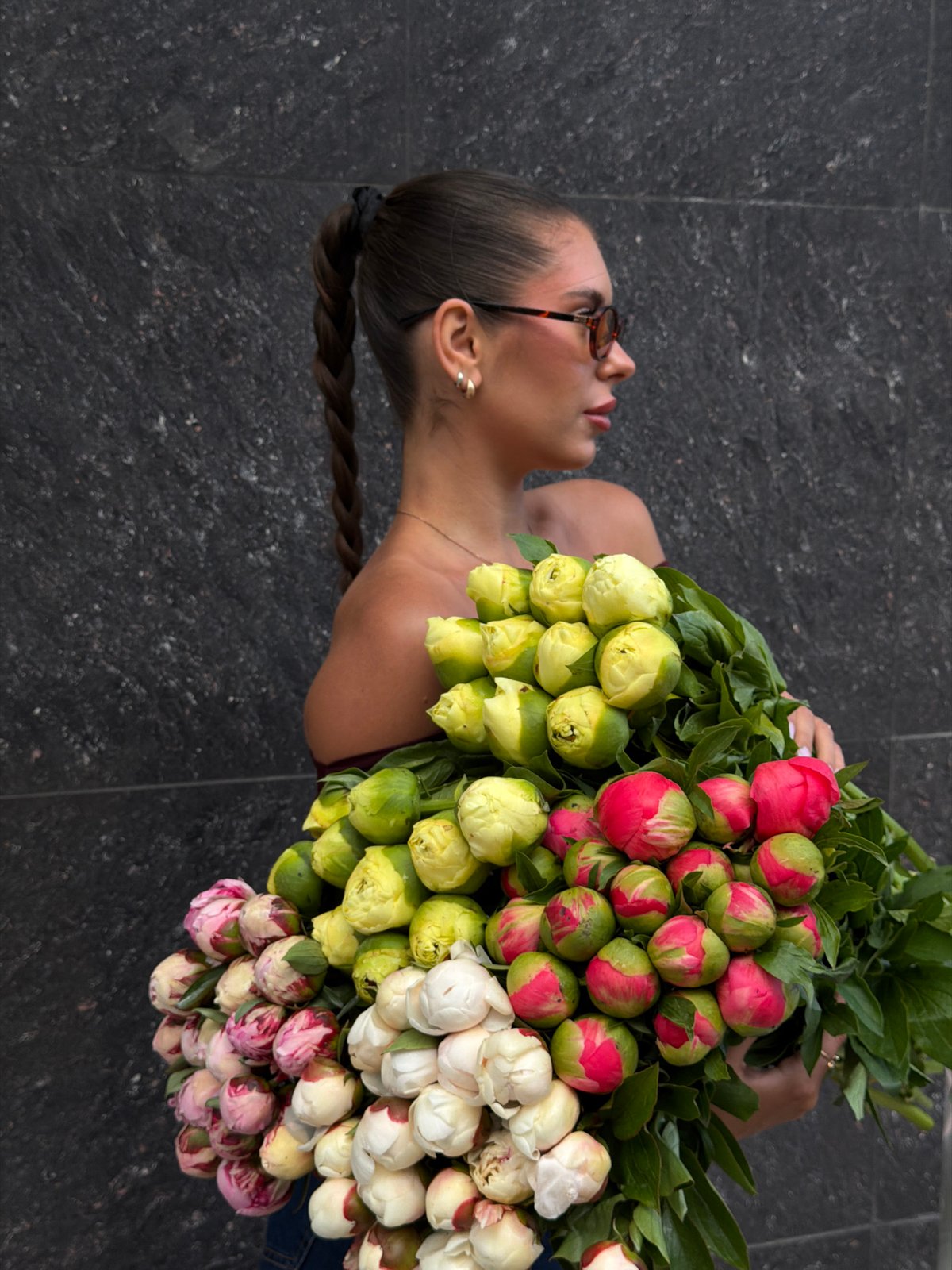 Woman holds colorful peony bouquet in Krasnoyarsk