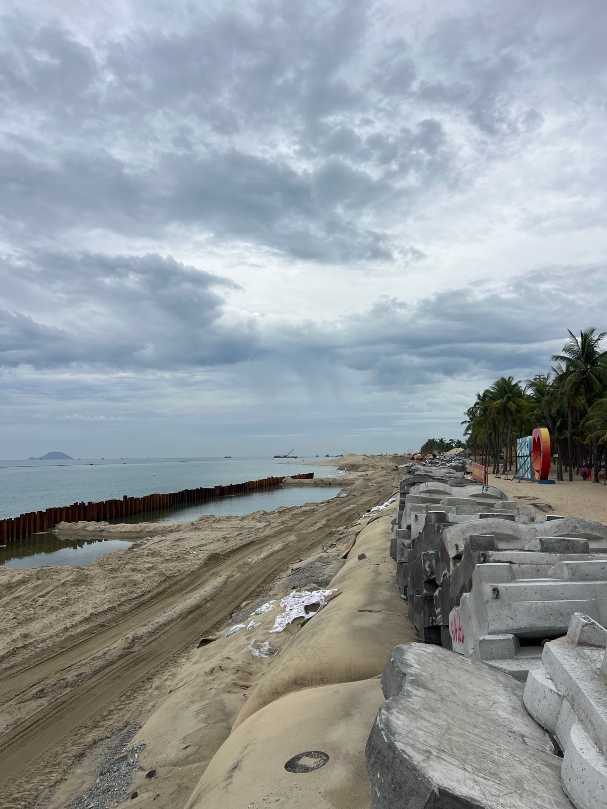 Hoi An beach: coastal barriers, thatched shade, and a rope swing