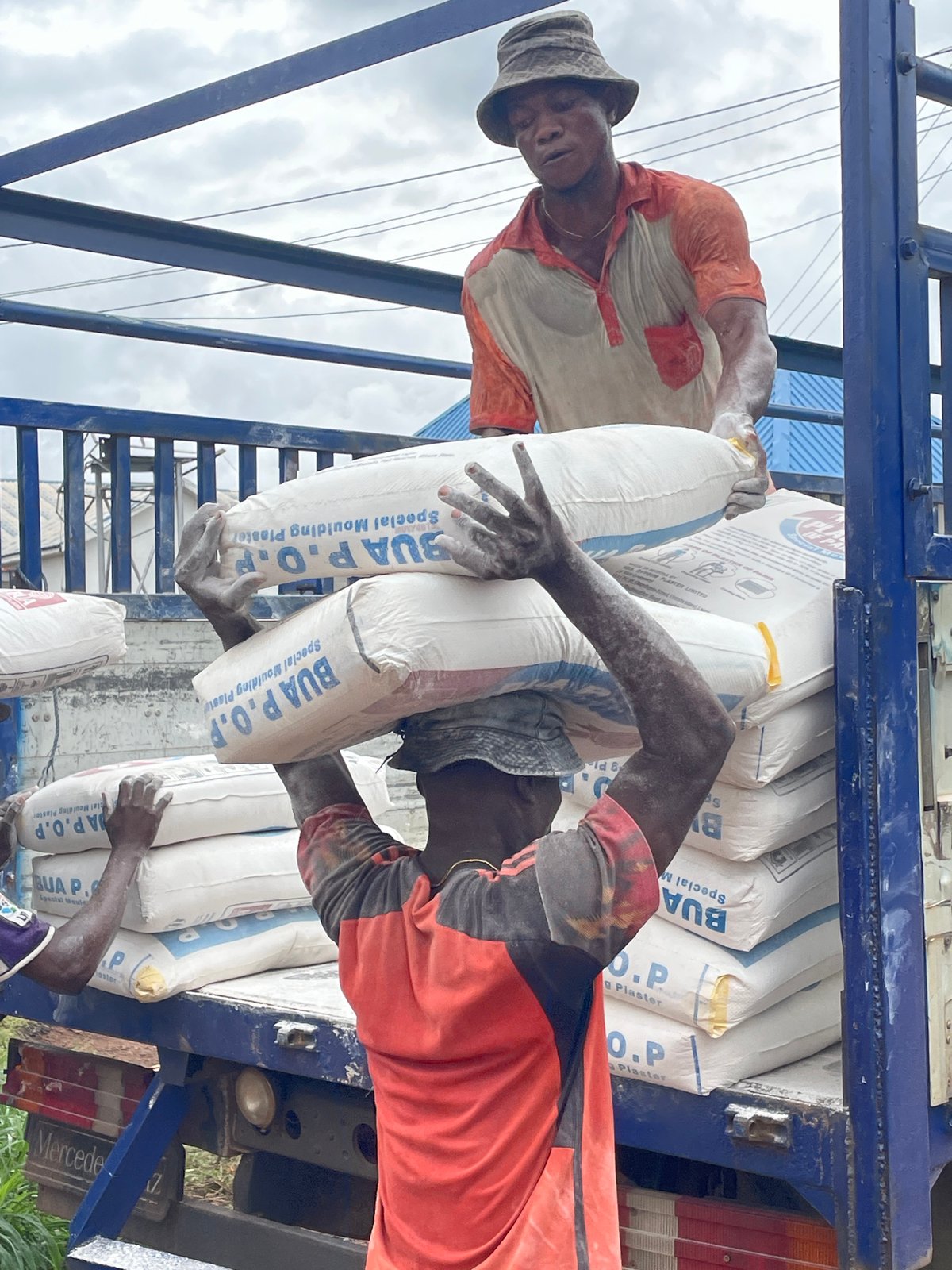 Construction materials being handled across an active Enugu supply site
