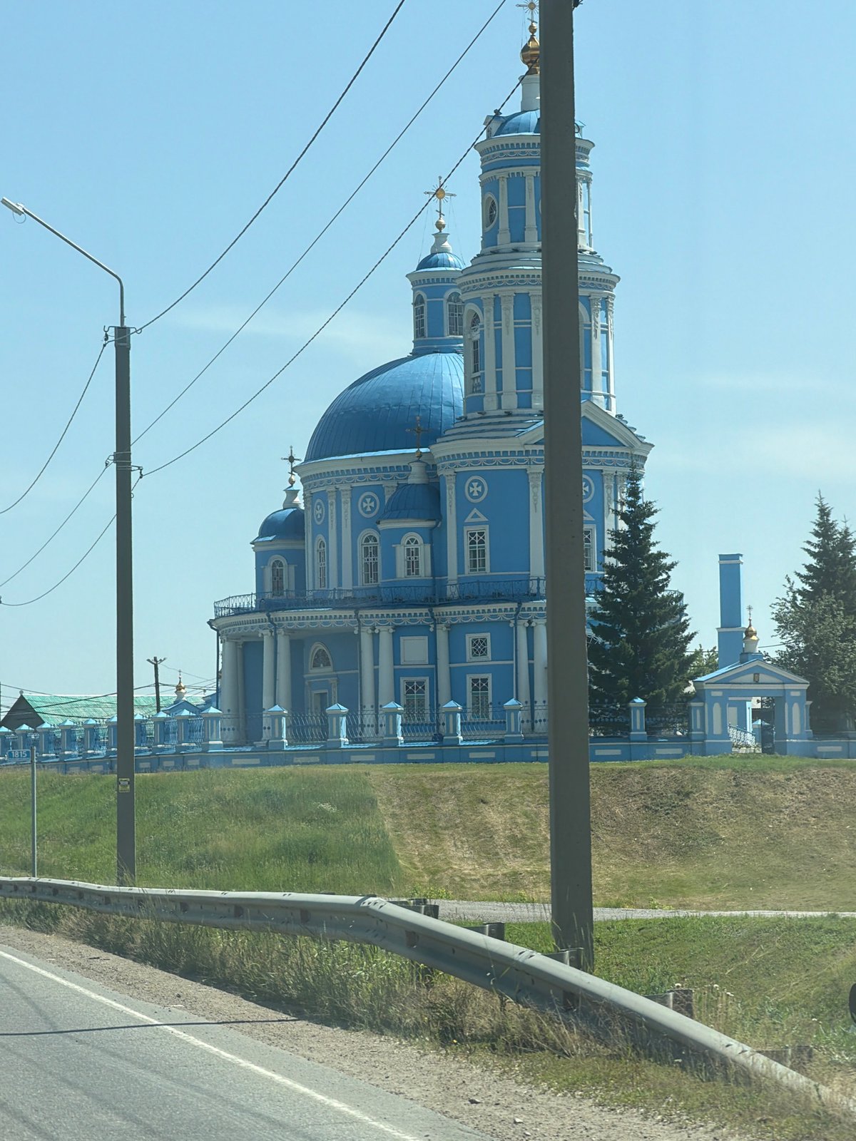 Blue and white Orthodox church with golden-crossed clock tower, Telma