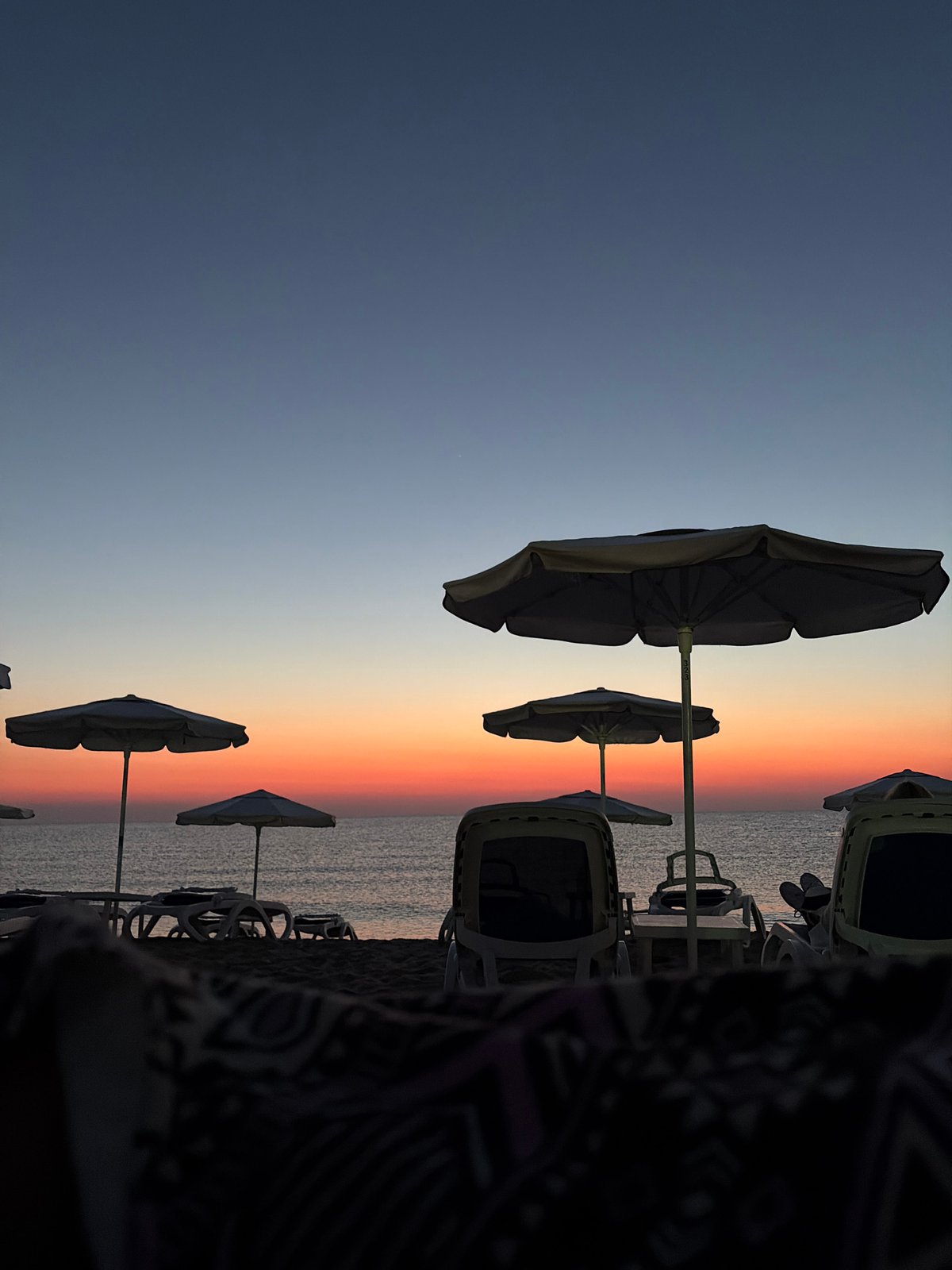 Sunset on a Bulgarian Black Sea beach, chairs empty, sky vivid
