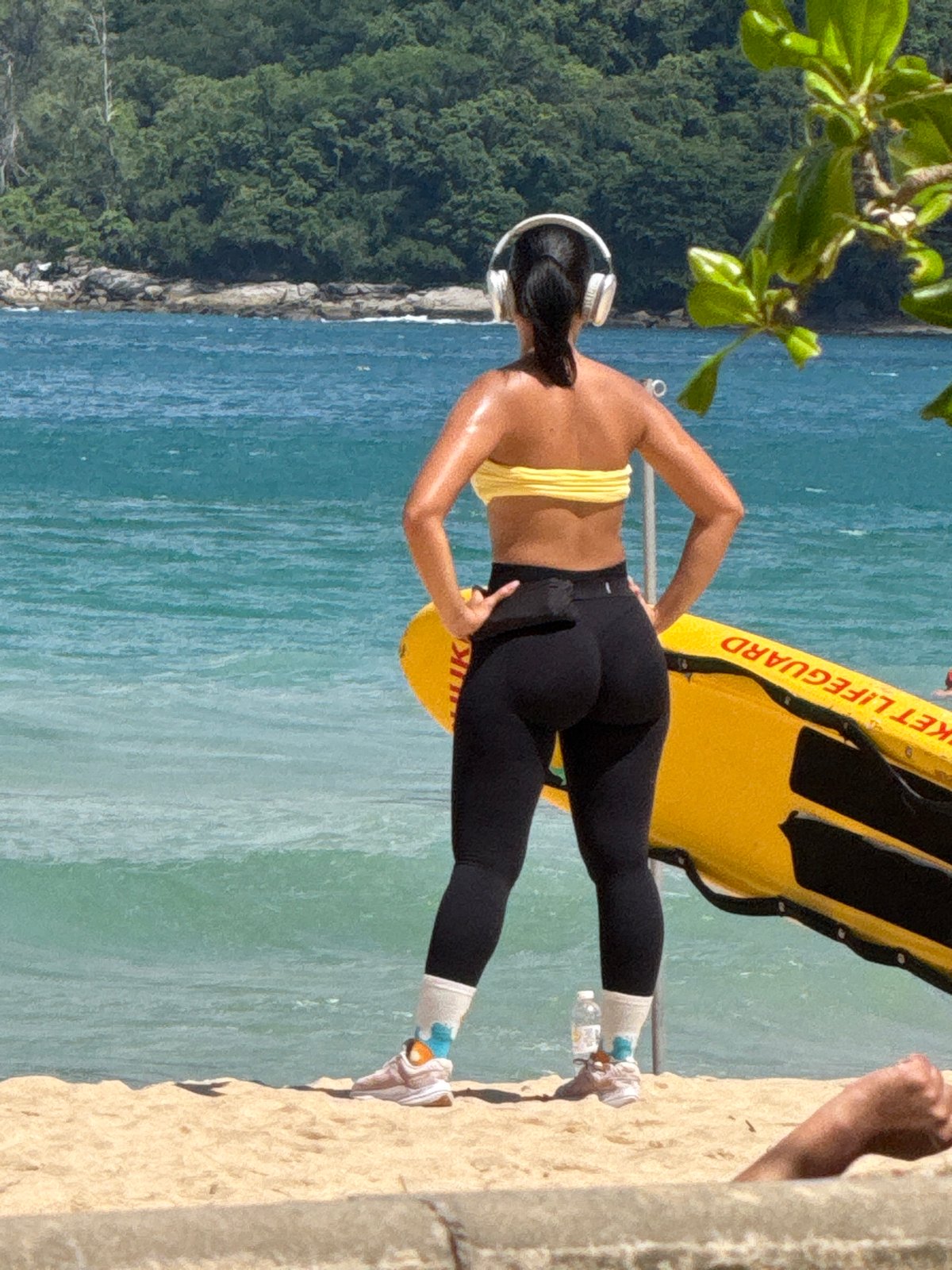 Beach morning in Rawai: scooters, shoreline hangout, paraglider overhead