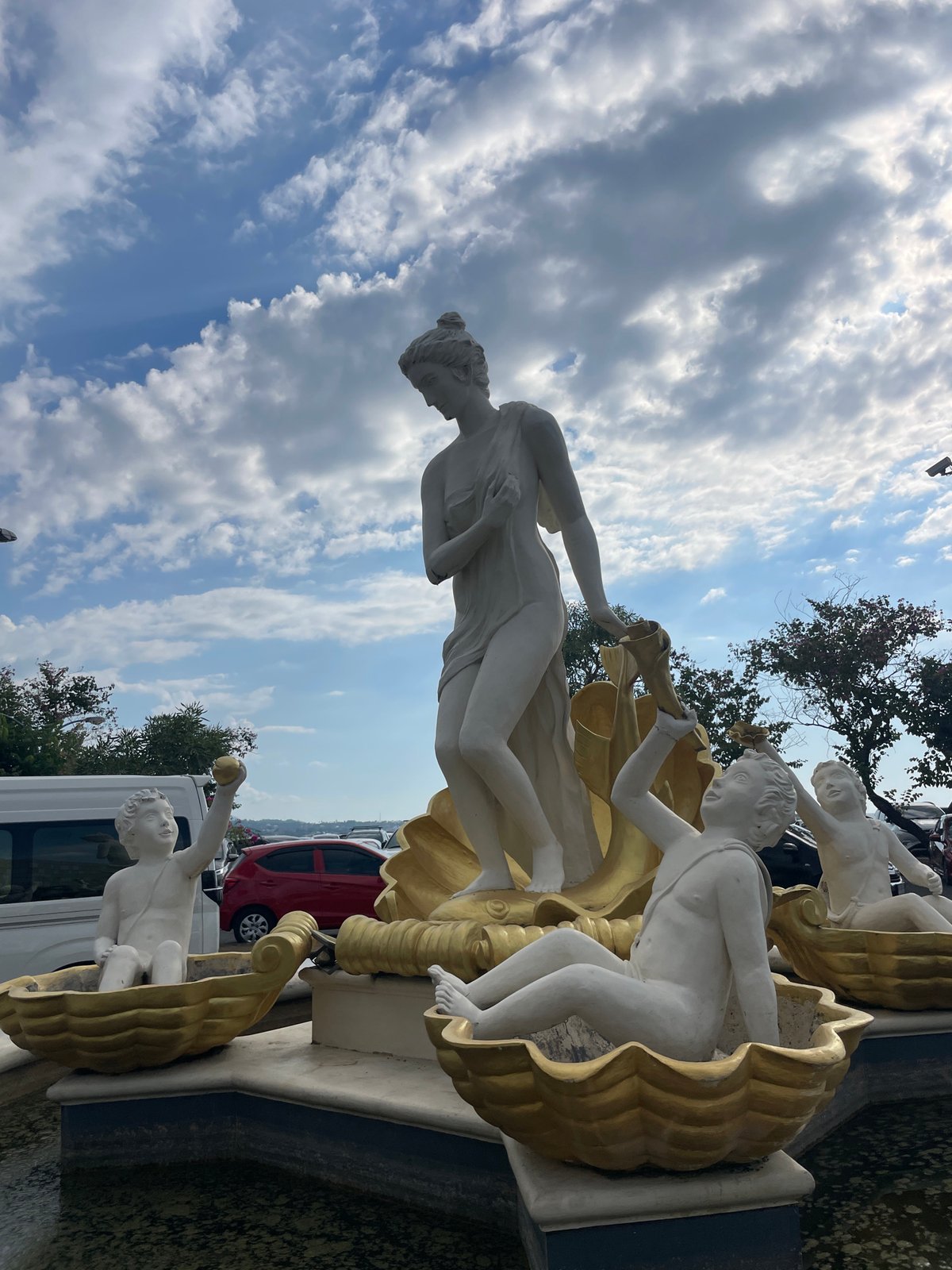 Manado's coastal promenade and shoreline sculpture on a clear morning
