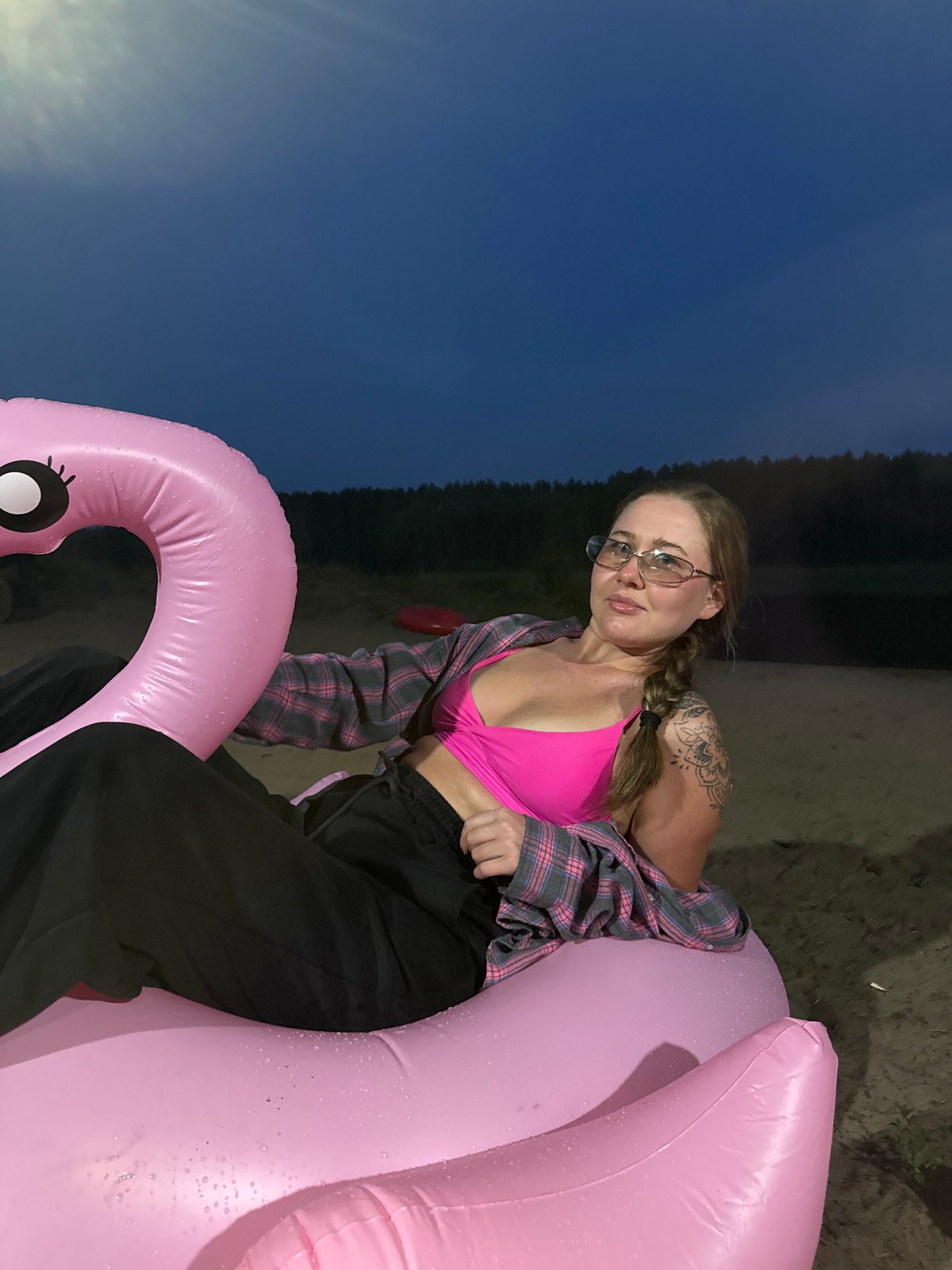 Pink flamingo float at a Russian lakeside beach, dusk
