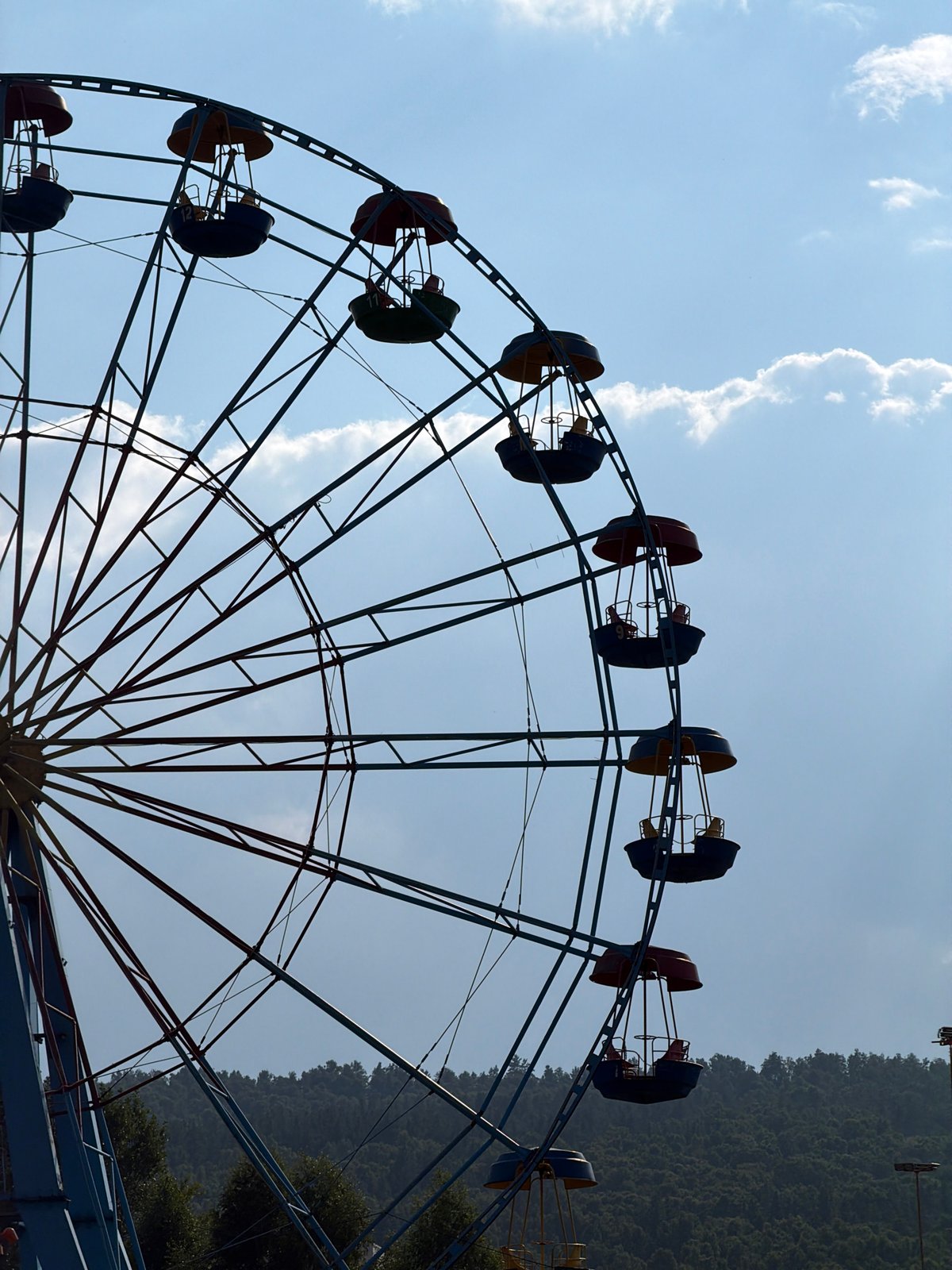 Ferris wheel and crepuscular rays fill an afternoon