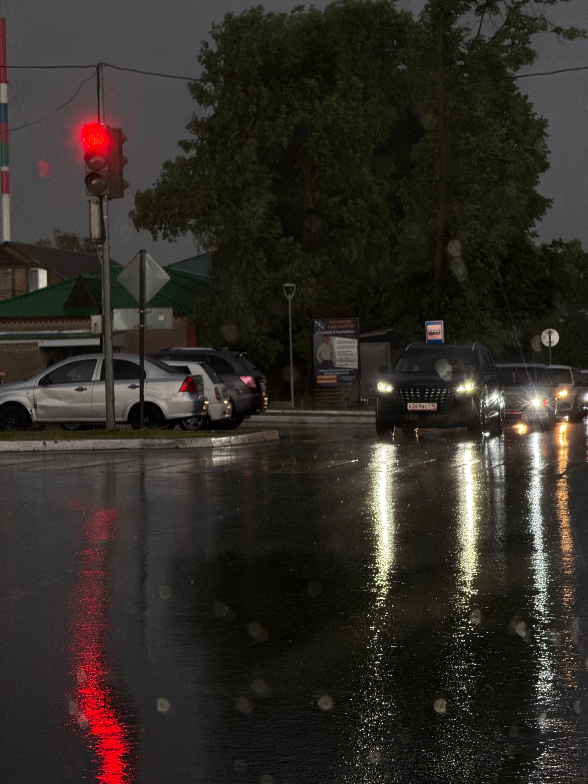 Rainy evening traffic observed at railroad crossing in Agryz, Russia