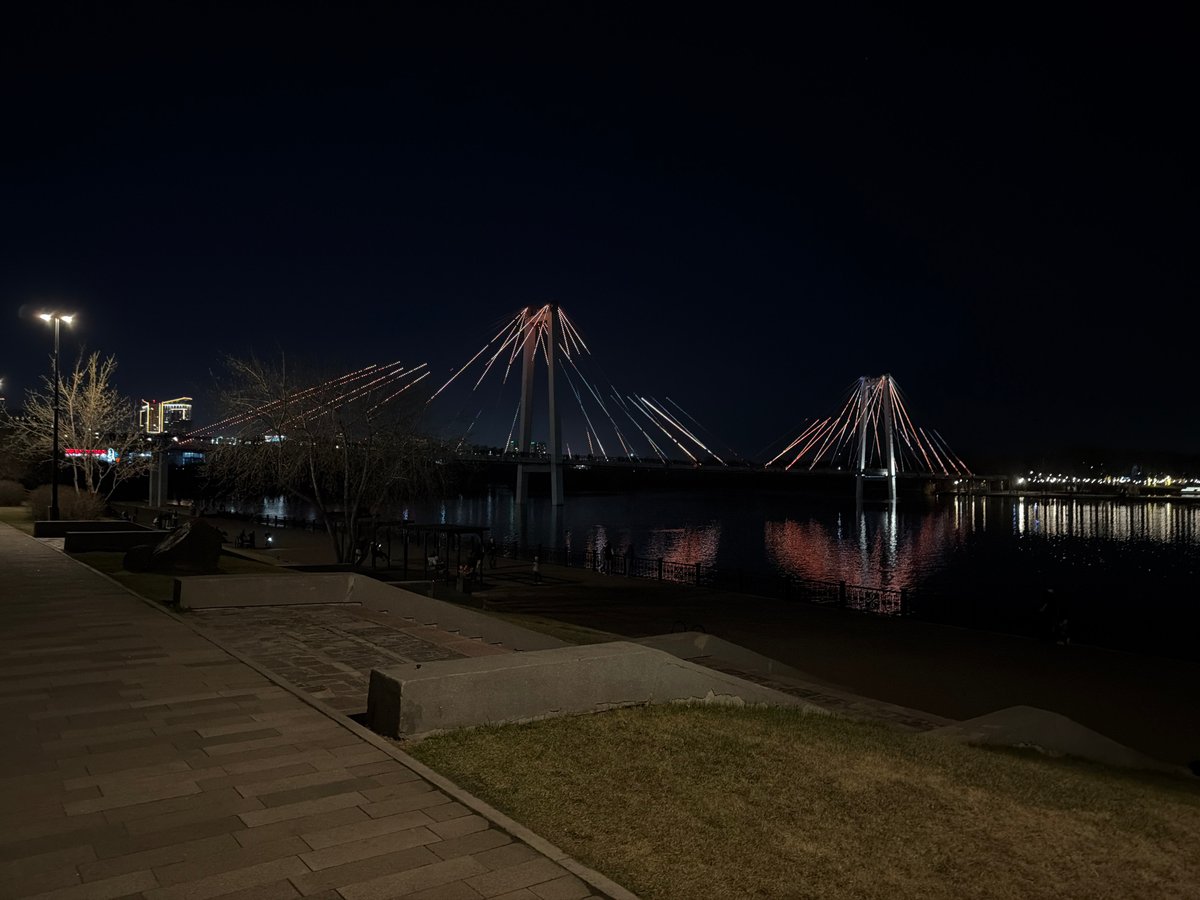 Illuminated bridges reflect on Yenisei River in Krasnoyarsk night